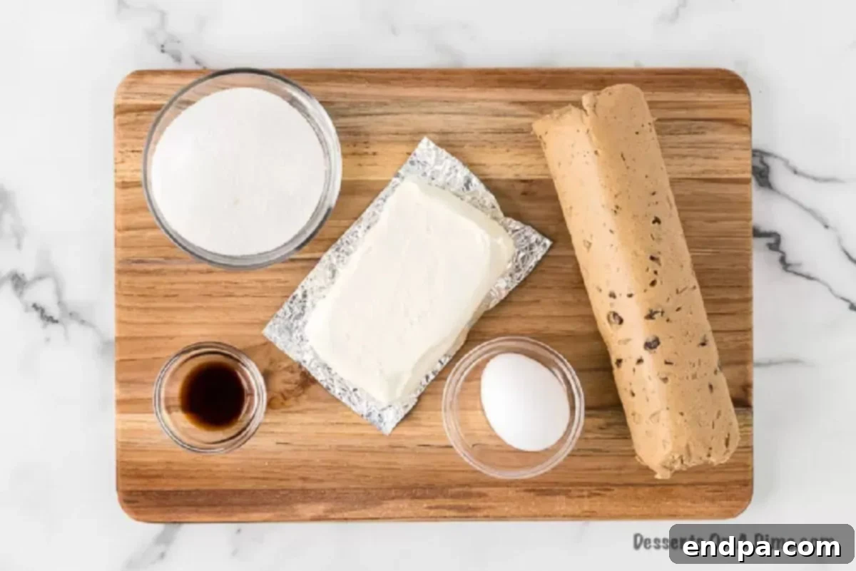 Key ingredients laid out: chocolate chip cookie dough, softened cream cheese, granulated sugar, an egg, and vanilla extract.