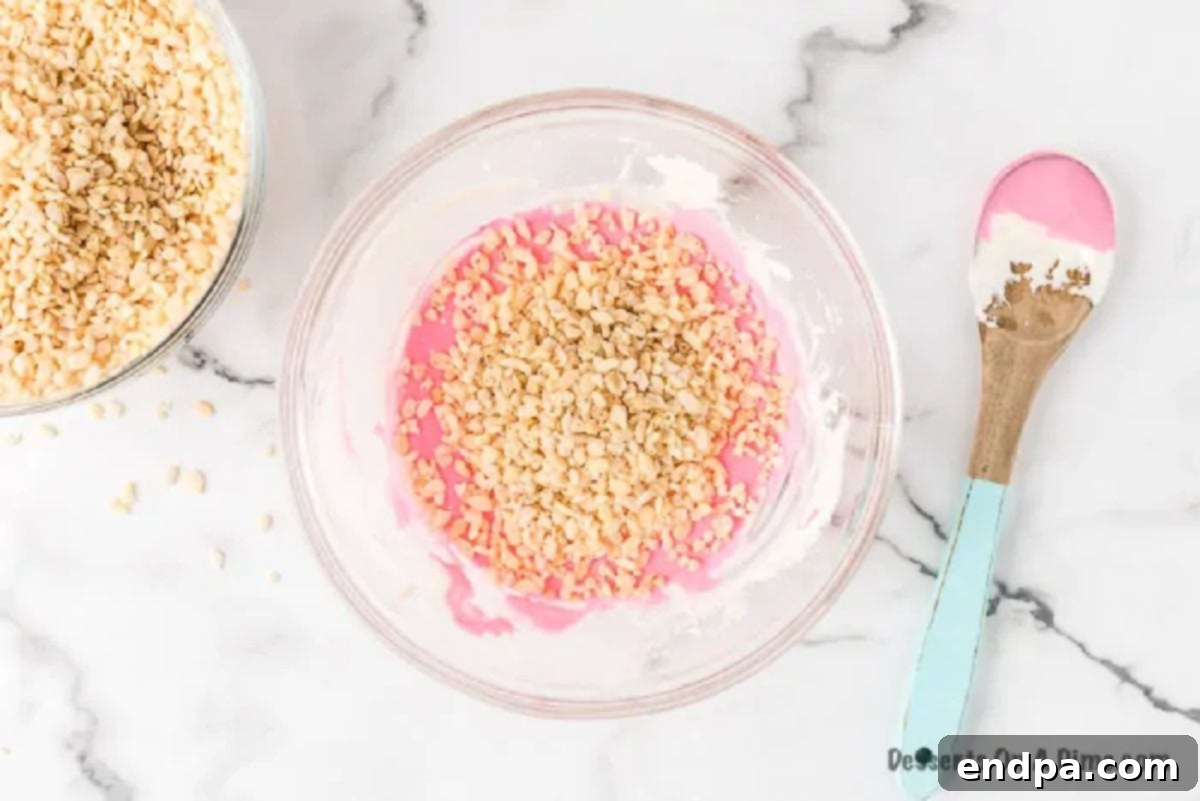 Rice Krispies cereal being mixed into the pink marshmallow mixture.