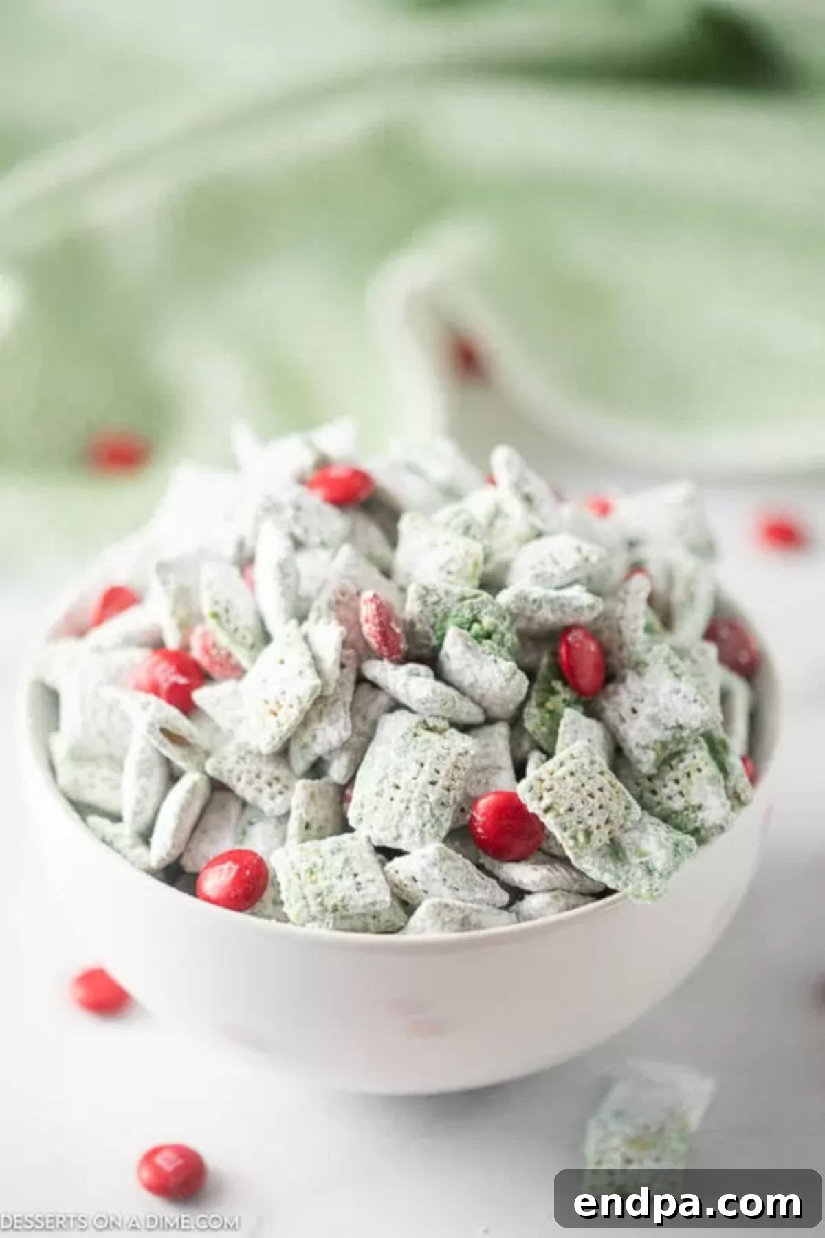 Whoville Christmas Crunch 3 Grinch puppy chow in a festive bowl, ready for serving at a holiday party.