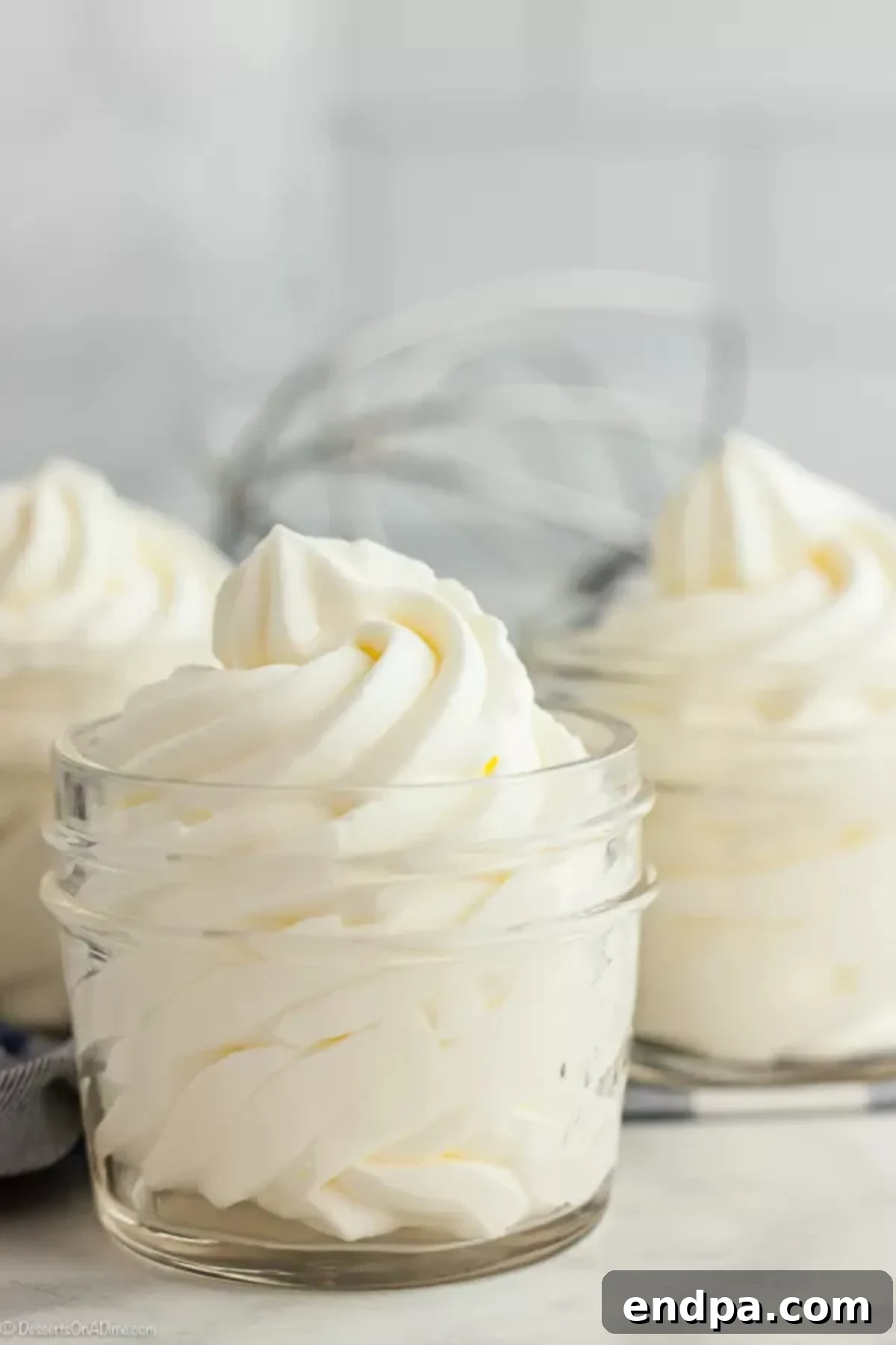 Once you try this Homemade Whipped Cream Recipe, you will never buy store bought whipped cream. This whipped cream recipes is easy with just 2 ingredients and tastes amazing. Try this heavy whipping cream recipes today. You will love this fresh whipped cream recipe! #dessertsonadime #whippedcream Homemade whipped cream in 3 small mason jars.