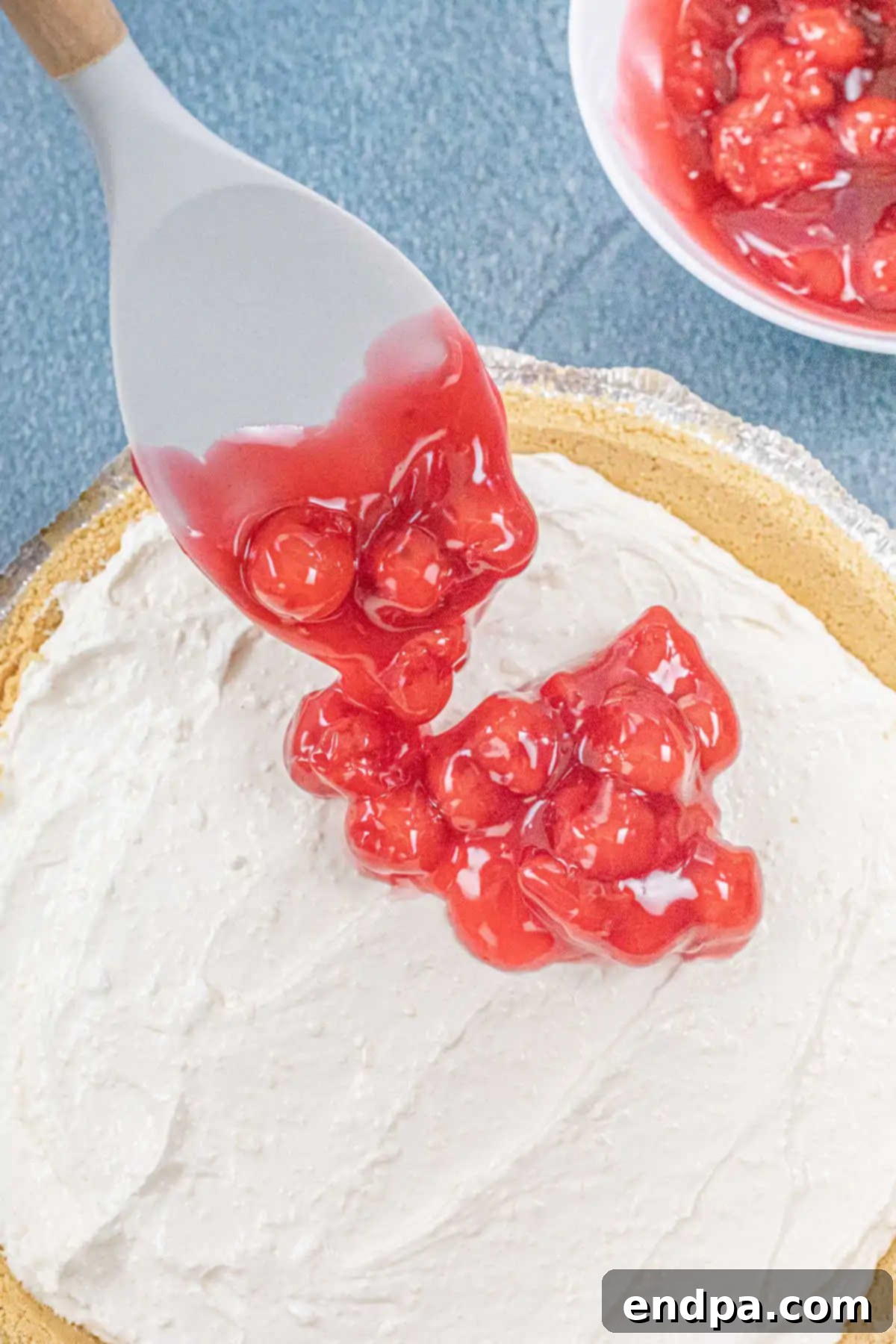 Chilled cherry pie filling spread over the set cheesecake layer.
