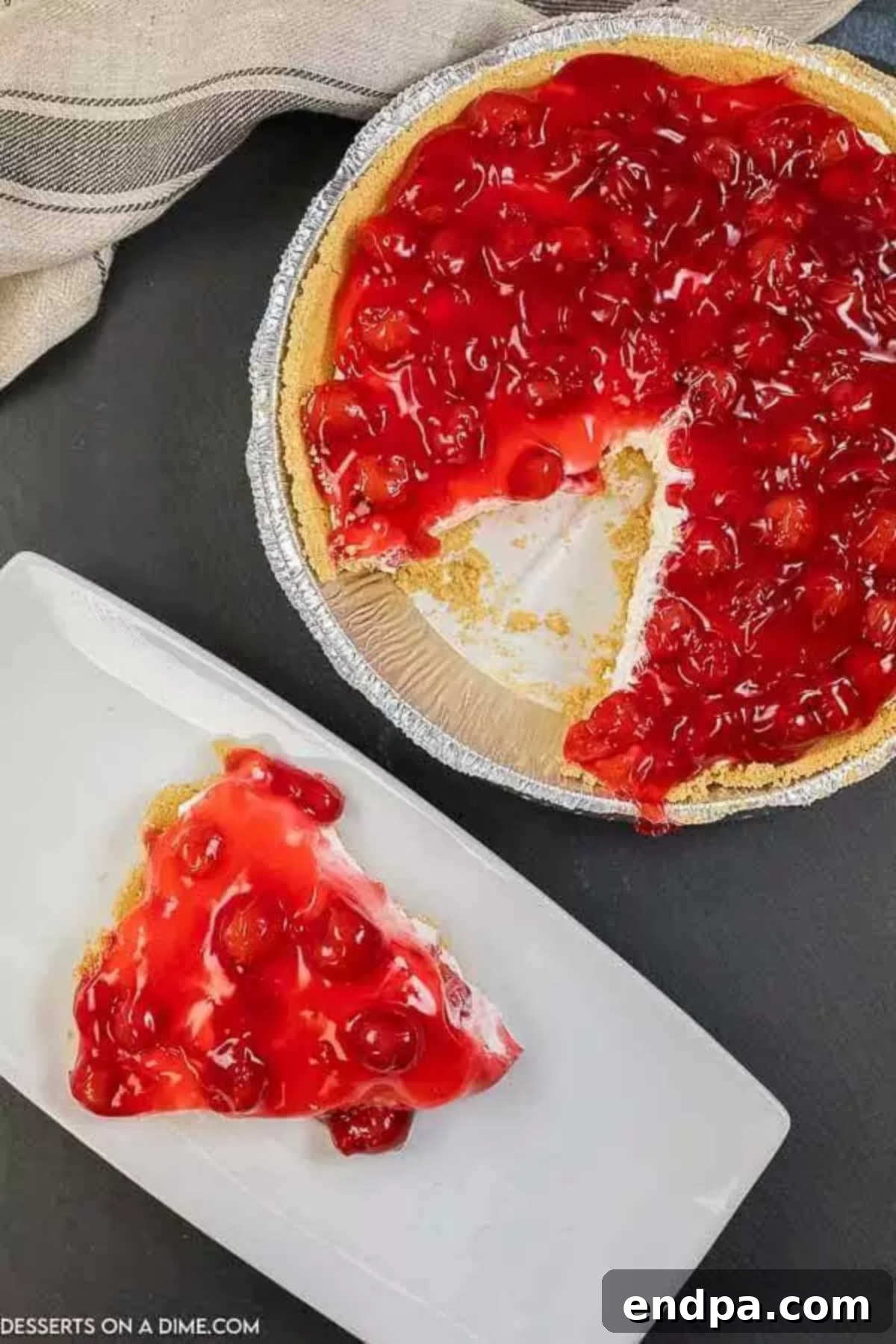 Whole No Bake Cherry Cheesecake with one slice removed, showcasing the perfect presentation.