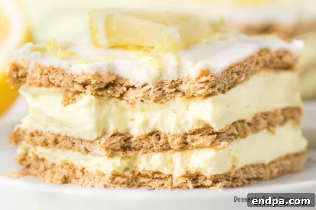 A slice of Lemon Icebox cake served on a white plate, showcasing its distinct layers of creamy lemon and graham crackers.