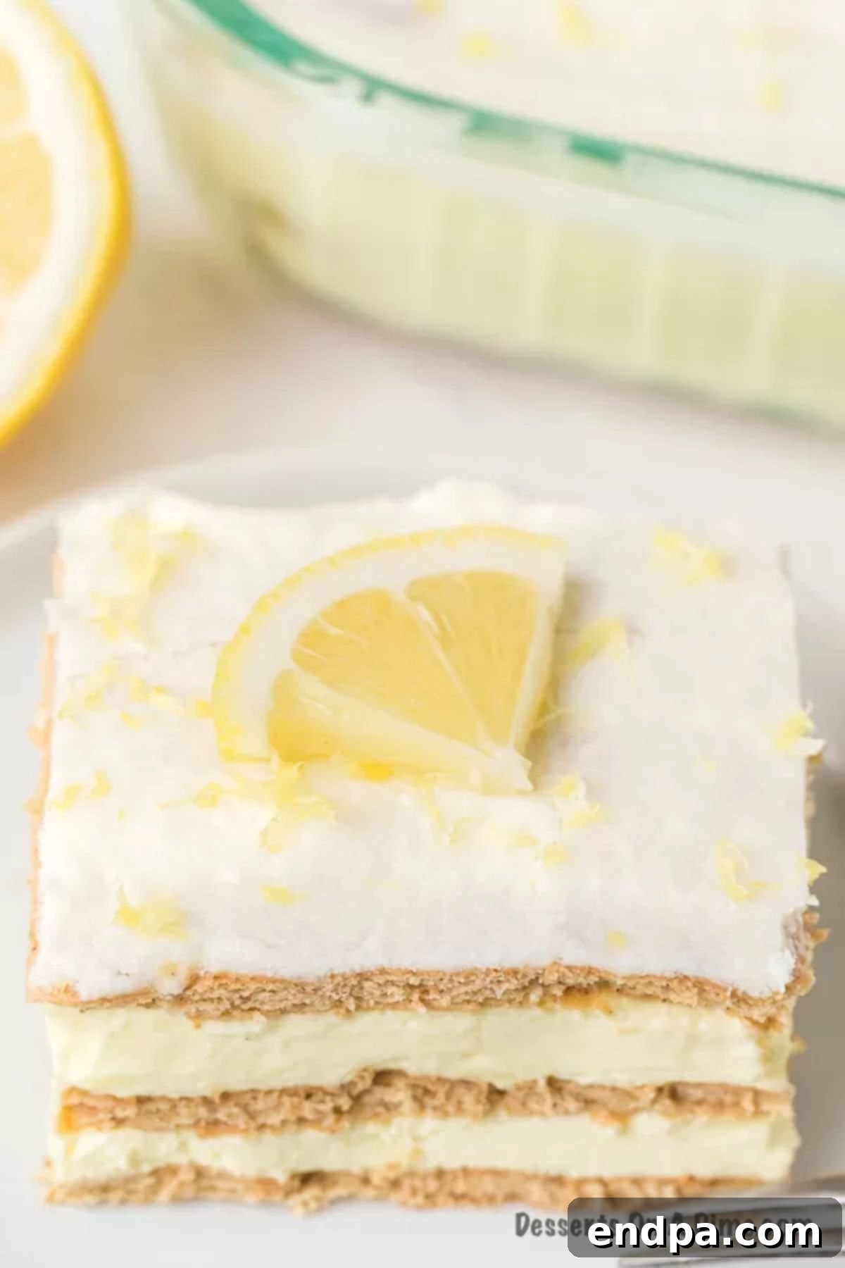 Beautifully sliced Lemon Icebox Cake garnished with fresh lemon wedges, ready to be served.