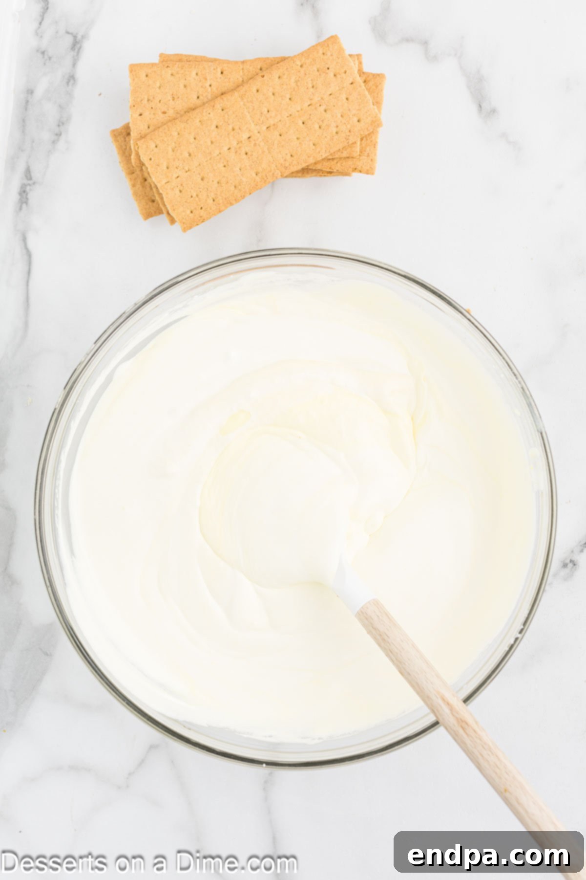 Mixing bowl with instant lemon pudding, Cool Whip, and whole milk combined to create a creamy filling.