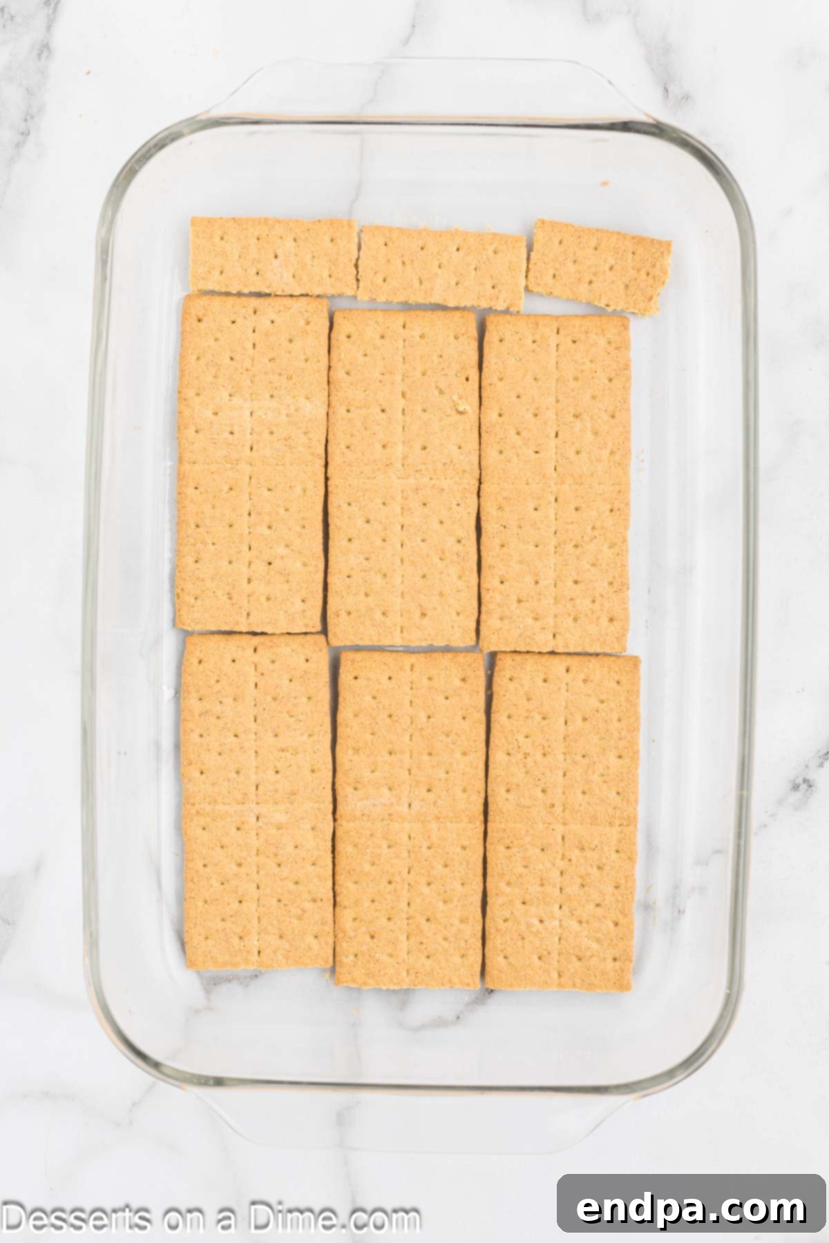 Graham crackers carefully layered at the bottom of a 9X13 inch baking dish.