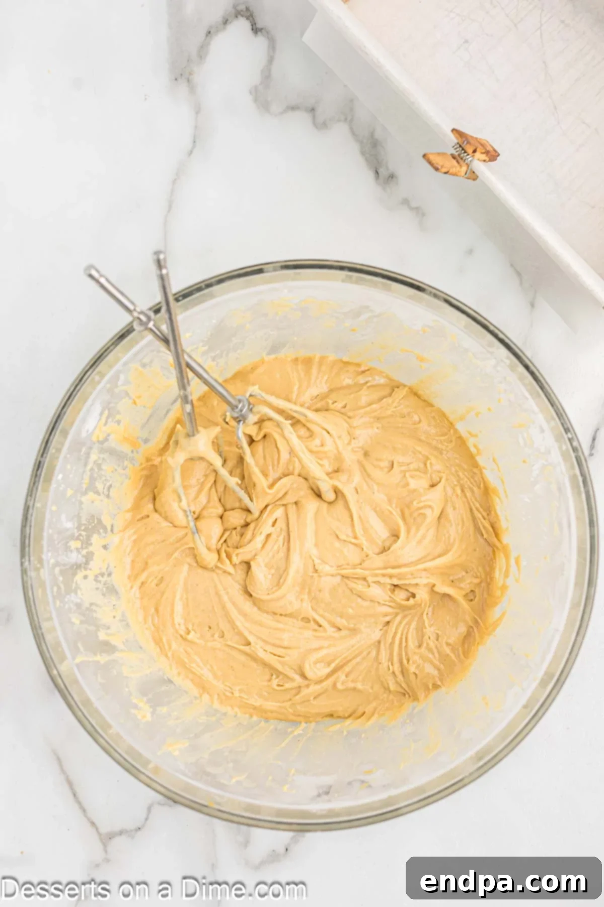 The wet ingredients, including an egg, milk, and creamy peanut butter, are being added to the bowl of dry ingredients, ready for mixing.