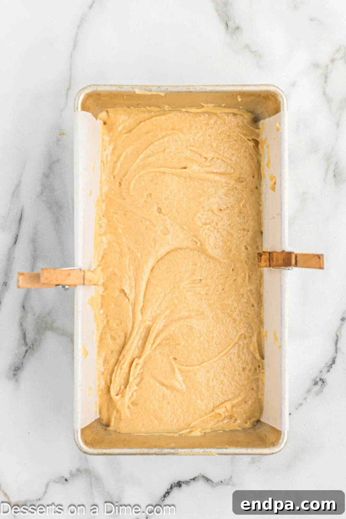Smooth peanut butter bread batter has been poured into a prepared 9x5-inch loaf pan, ready for baking.