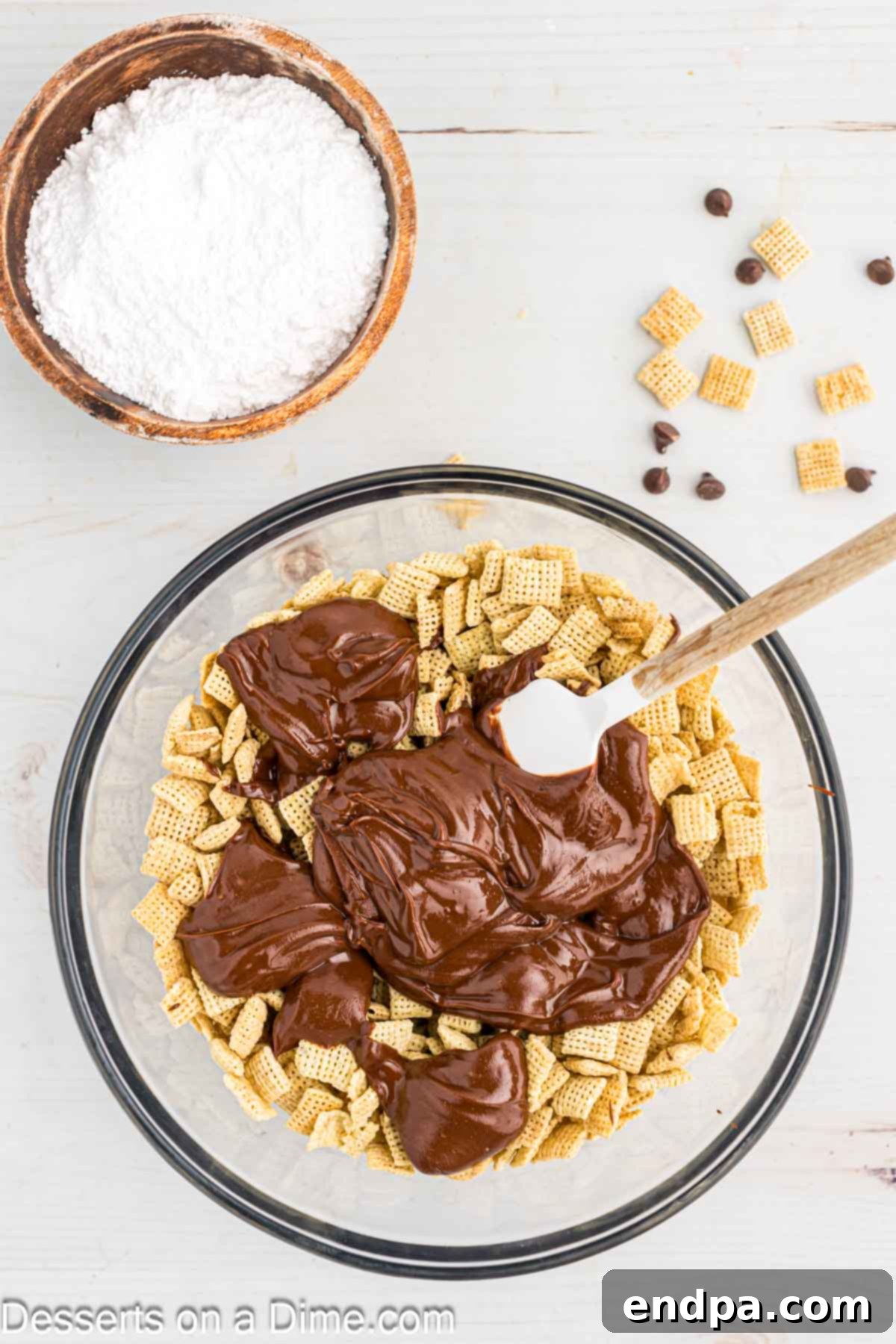 Pouring the melted chocolate and peanut butter mixture over Chex cereal in a bowl.