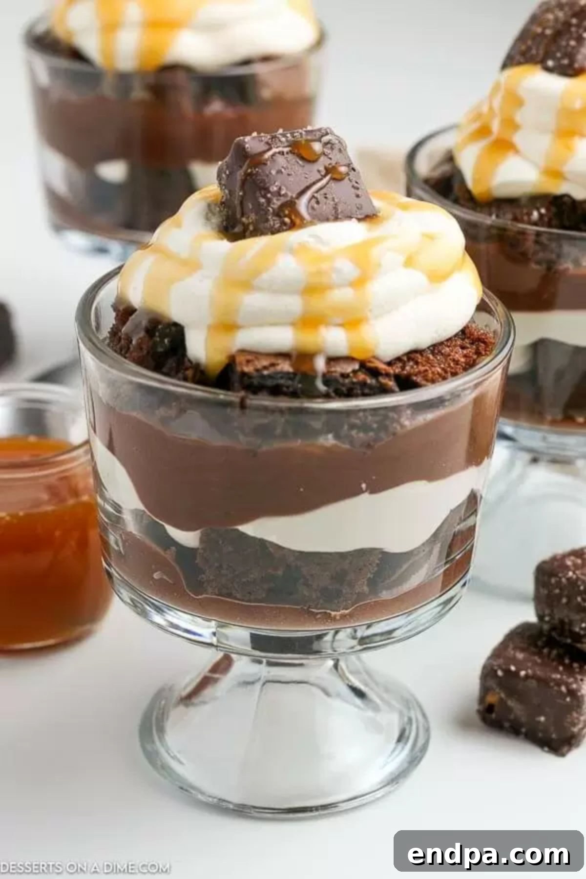 Decadent Layered Chocolate Trifle 13 Chocolate Trifle in a glass bowl topped with whipped cream and caramel syrup