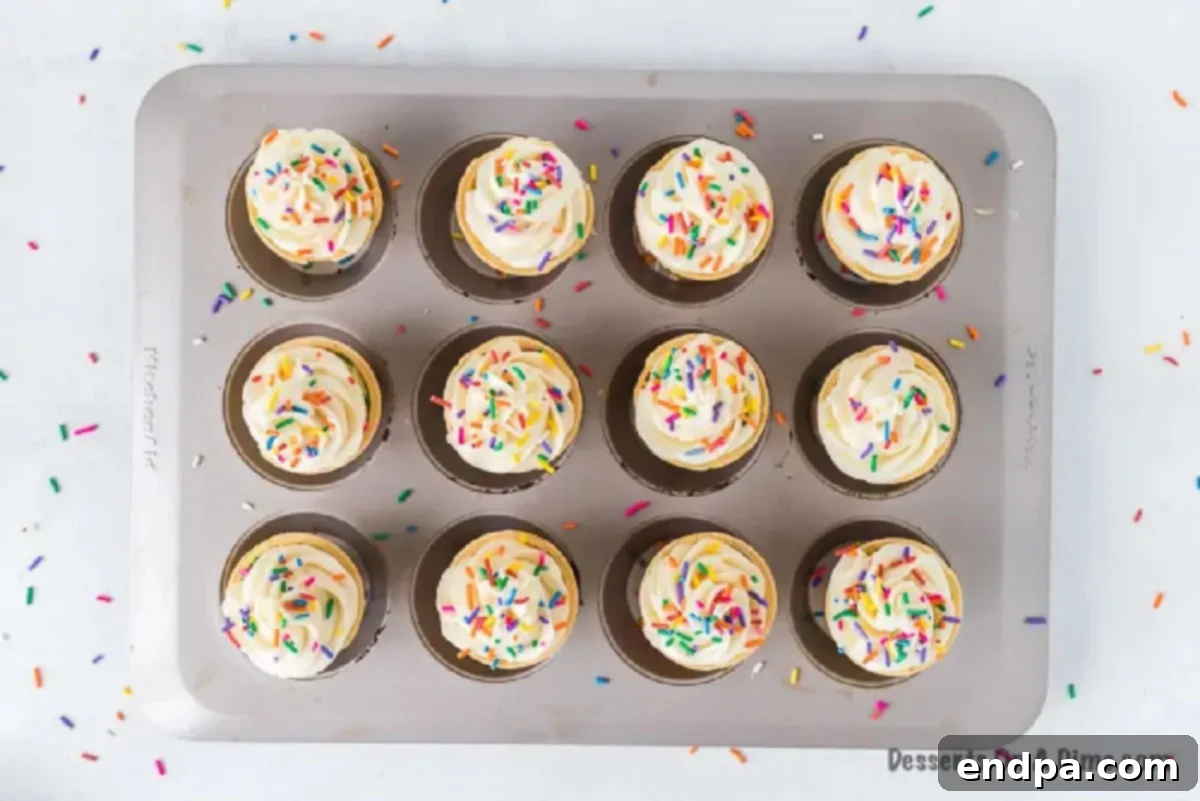 Sweet Cones of Cake 8 Finished ice cream cone cupcakes topped with swirled frosting and colorful sprinkles.