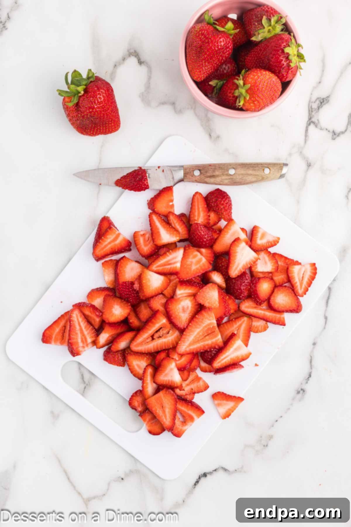 Sliced strawberries on cutting board.