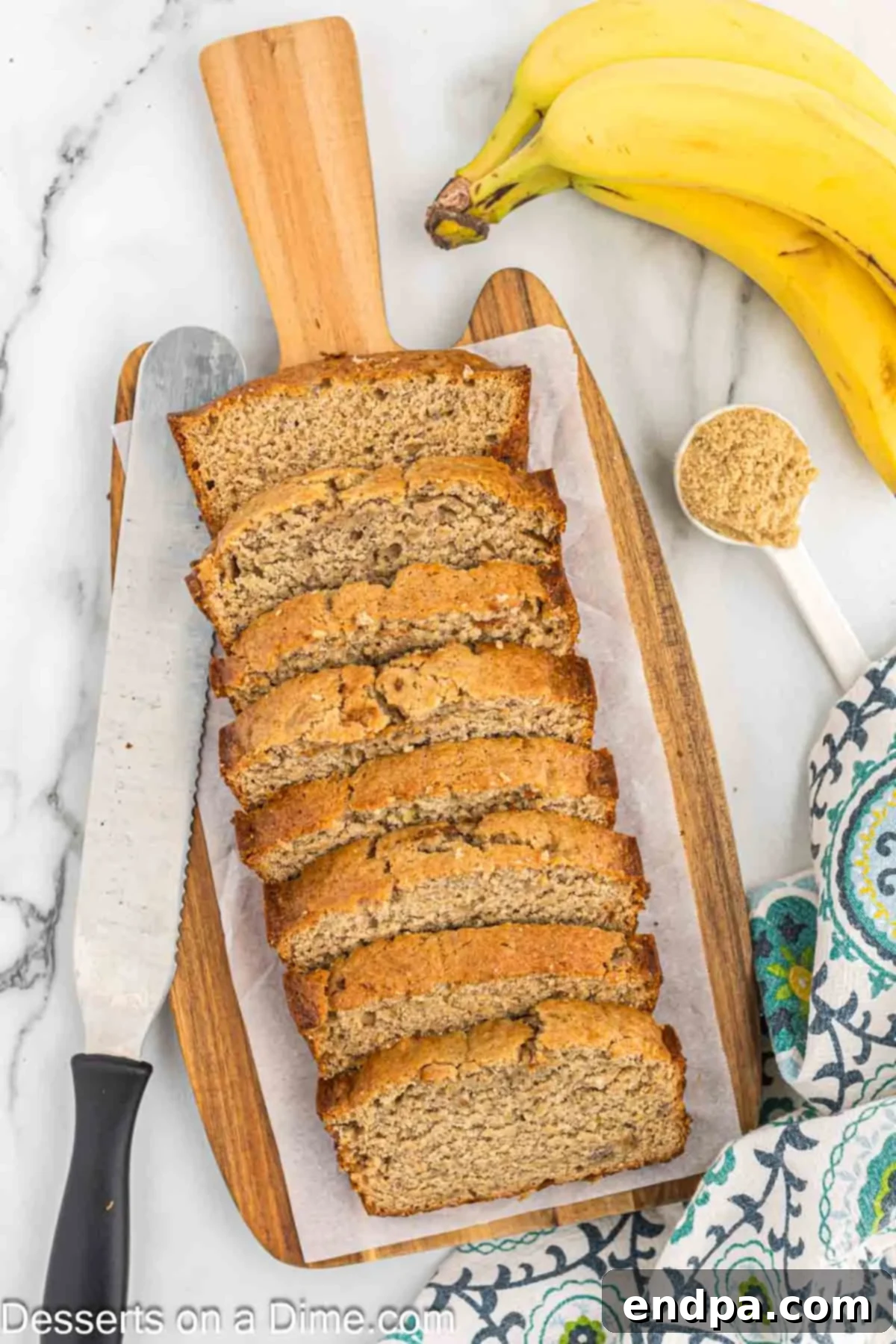 A perfectly sliced loaf of golden brown sugar banana bread on a rustic cutting board, showcasing its moist texture.