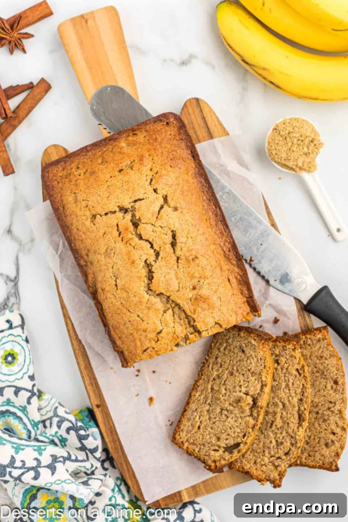 A hand gently slicing a freshly baked loaf of Brown Sugar Banana Bread, ready to be served.