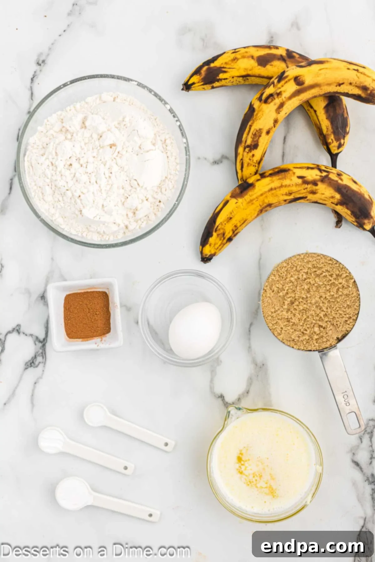 Essential ingredients for baking delicious banana bread: ripe bananas, light brown sugar, flour, butter, egg, vanilla extract, cinnamon, baking soda, baking powder, and salt.