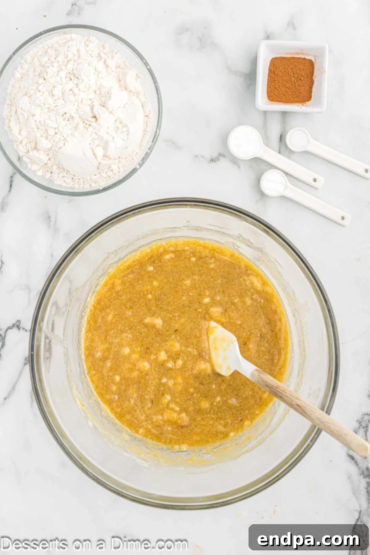 Mashed ripe bananas in a large mixing bowl, ready for the wet ingredients.