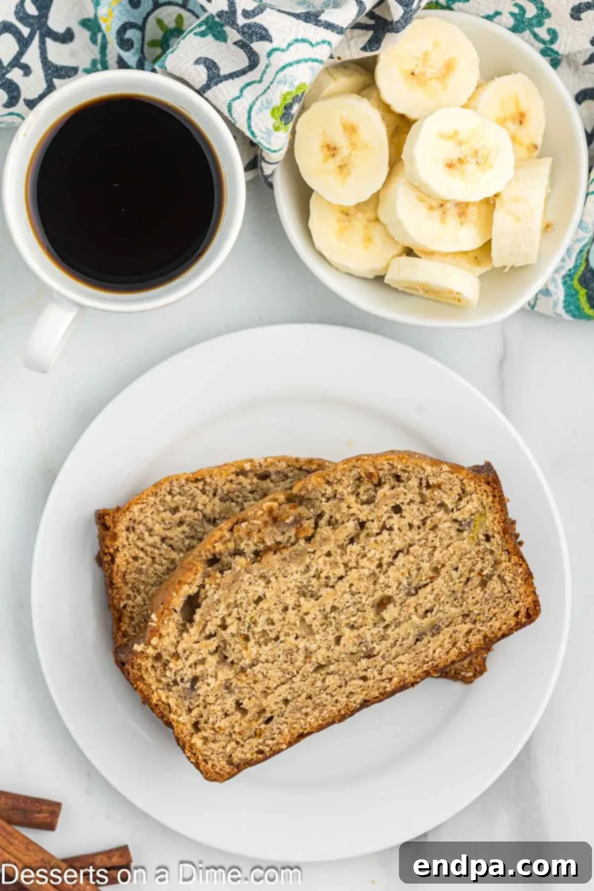 Several slices of moist Brown Sugar Banana Bread arranged artfully on a white plate, ready to be enjoyed.