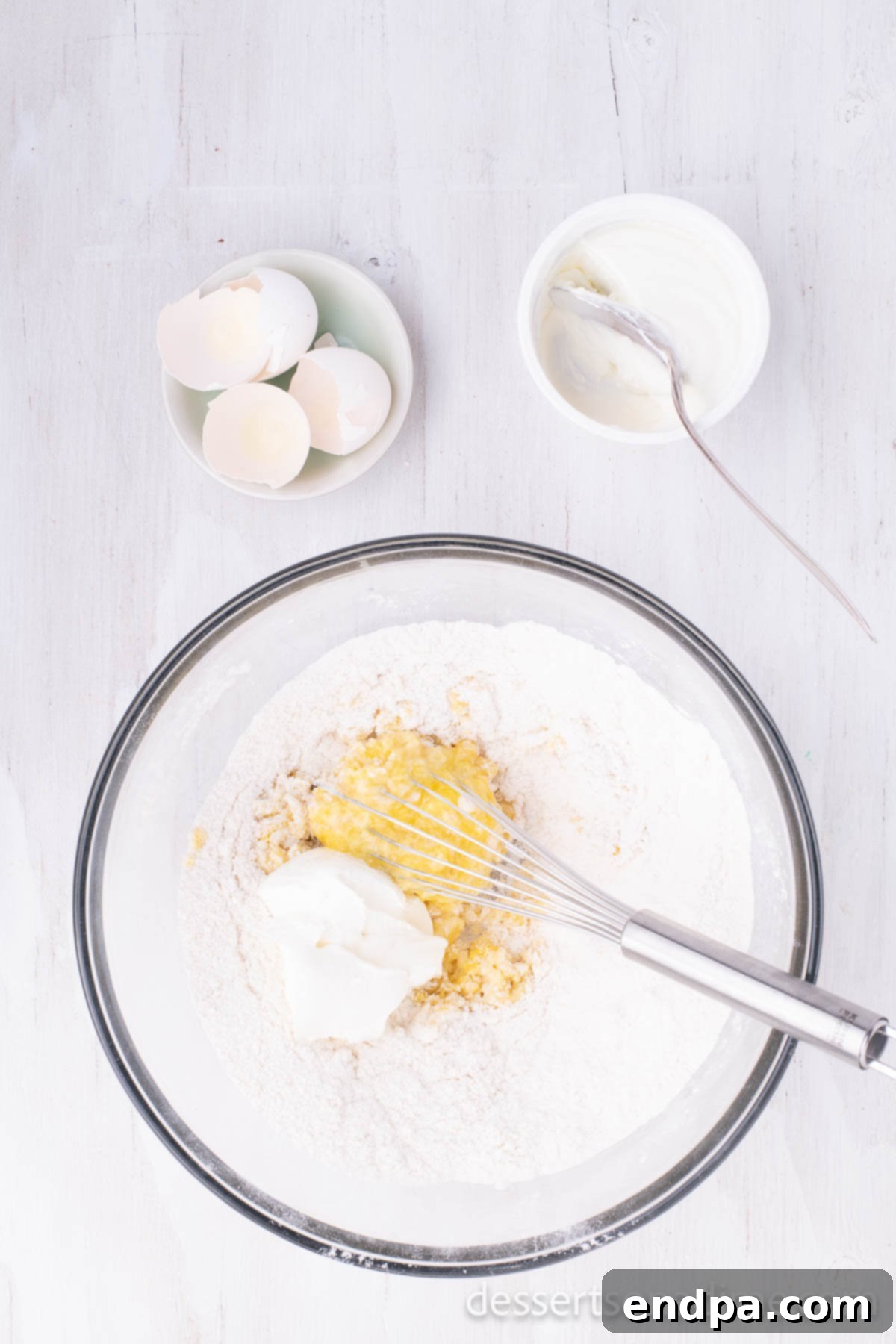 Classic Texas Chocolate Sheet Cake 2 Bowl of dry cake ingredients with sour cream and eggs whisked in, showing a smooth batter texture.