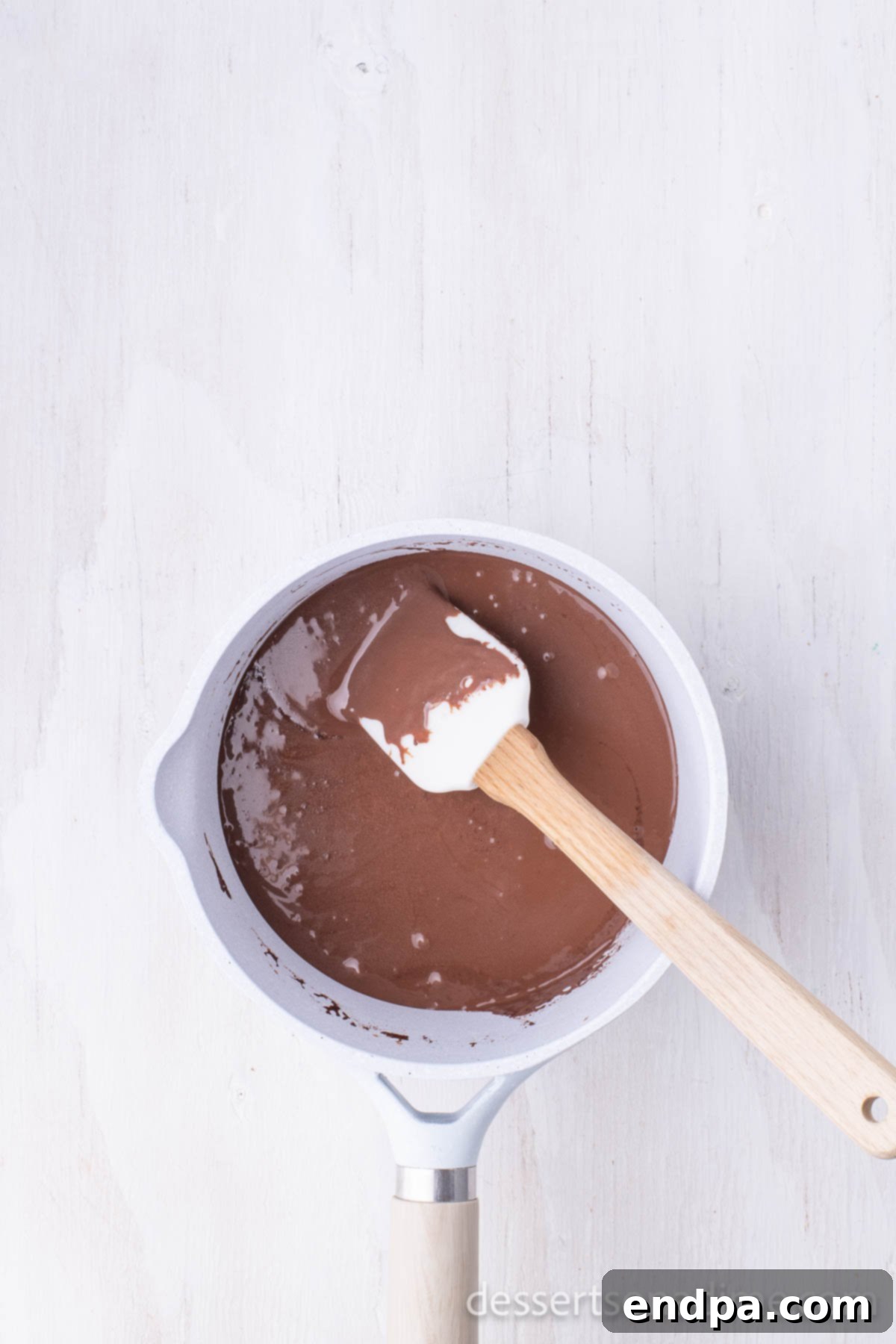 Classic Texas Chocolate Sheet Cake 6 Saucepan with frosting mixture bubbling gently, ready to be removed from heat.