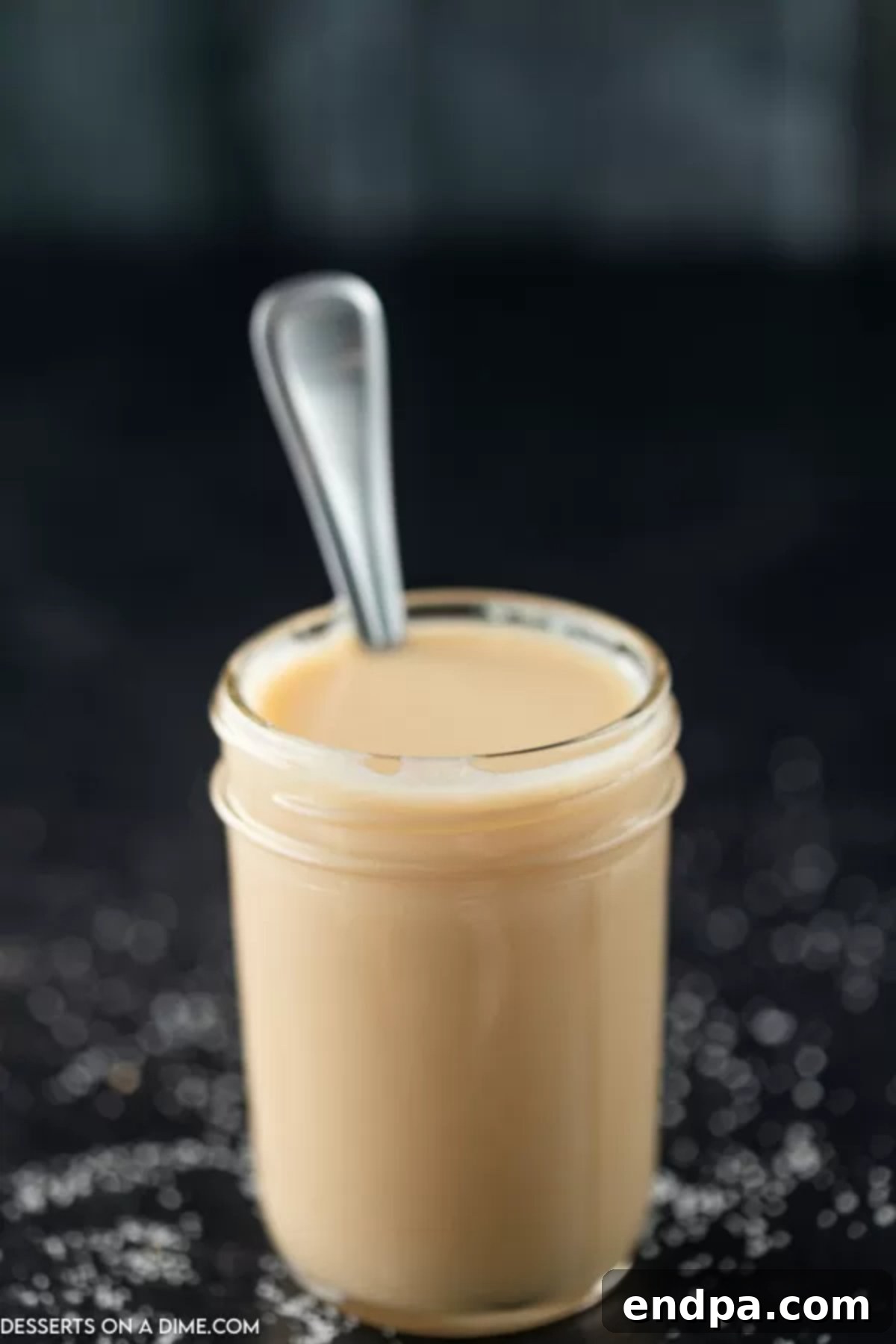 Sweetened Condensed Milk from Scratch 8 Homemade Sweetened Condensed Milk in a mason jar with a spoon