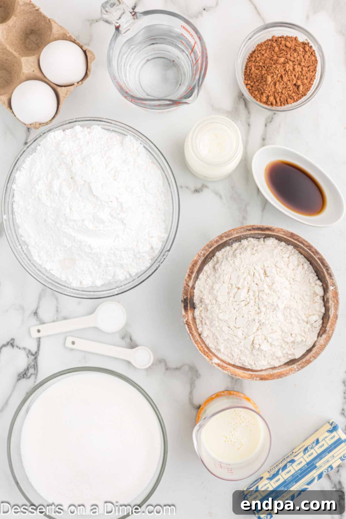 Effortless Decadent Chocolate Cake 3 A flat lay photograph showcasing key ingredients for a delicious chocolate cake: softened butter, unsweetened cocoa powder, baking soda, buttermilk, and vanilla extract.