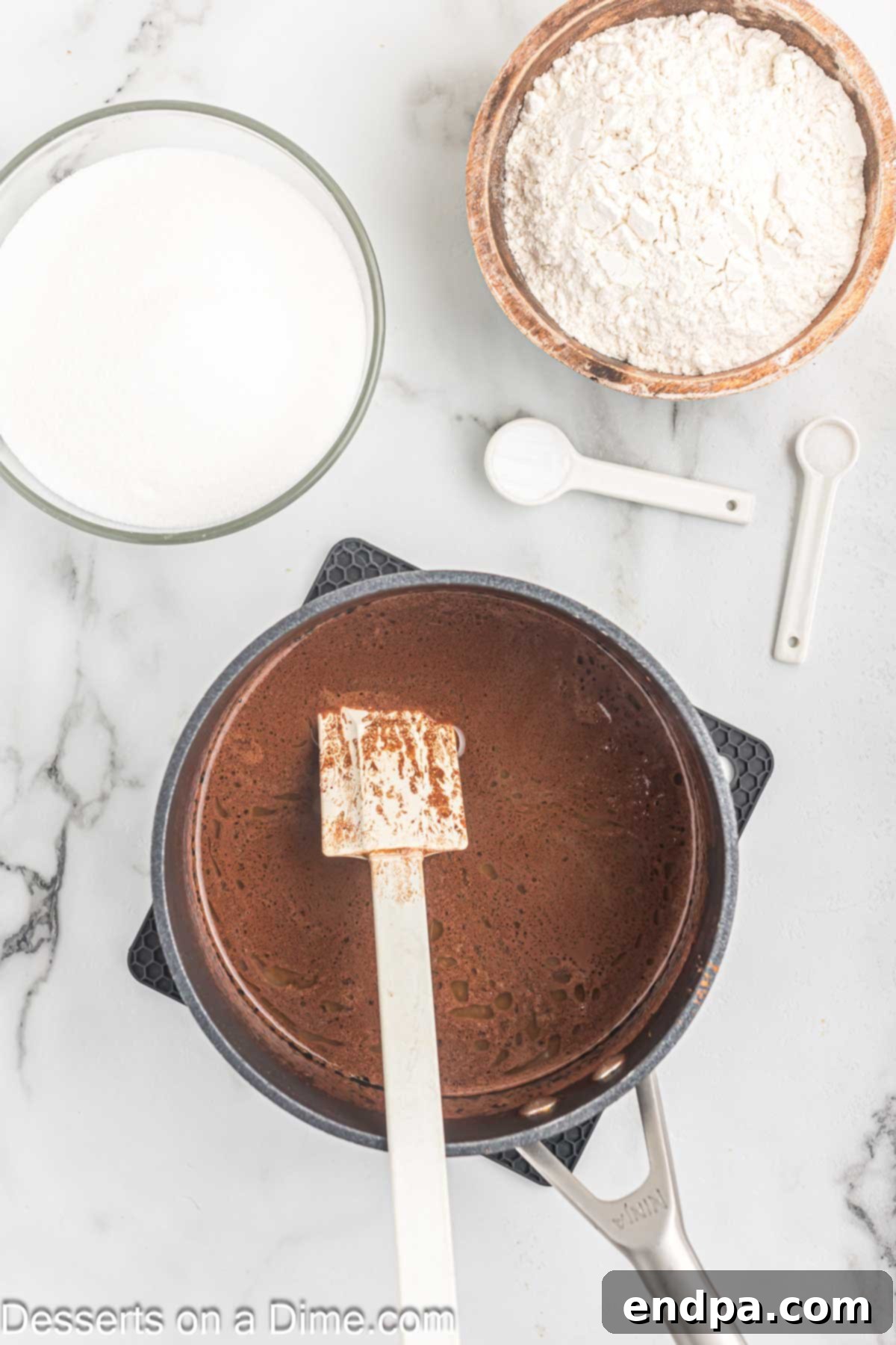 Effortless Decadent Chocolate Cake 4 Butter and cocoa powder melting in a saucepan with water, creating a rich chocolate base.