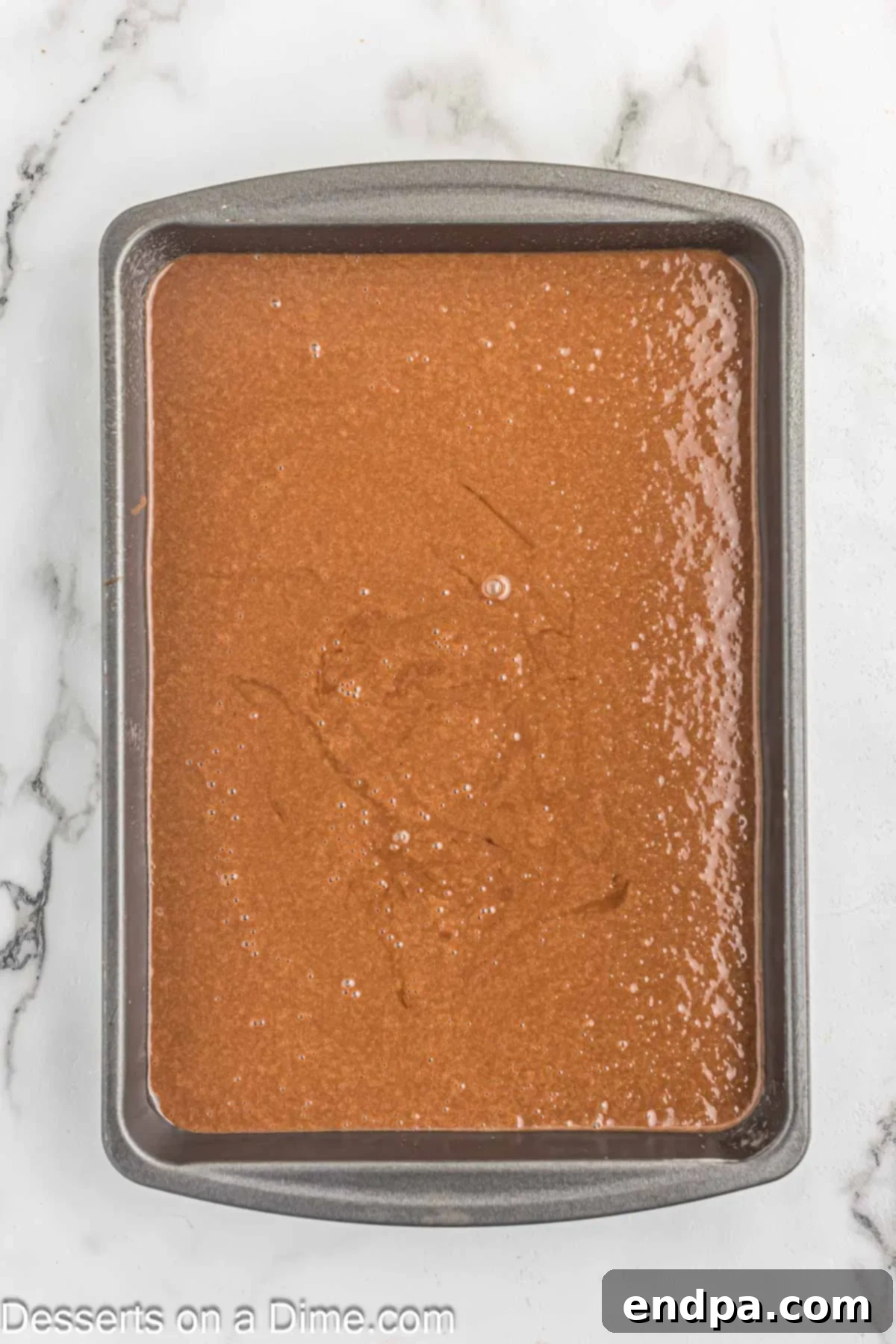 Effortless Decadent Chocolate Cake 6 Smooth chocolate cake batter being poured evenly into a prepared 9x13 inch baking pan.