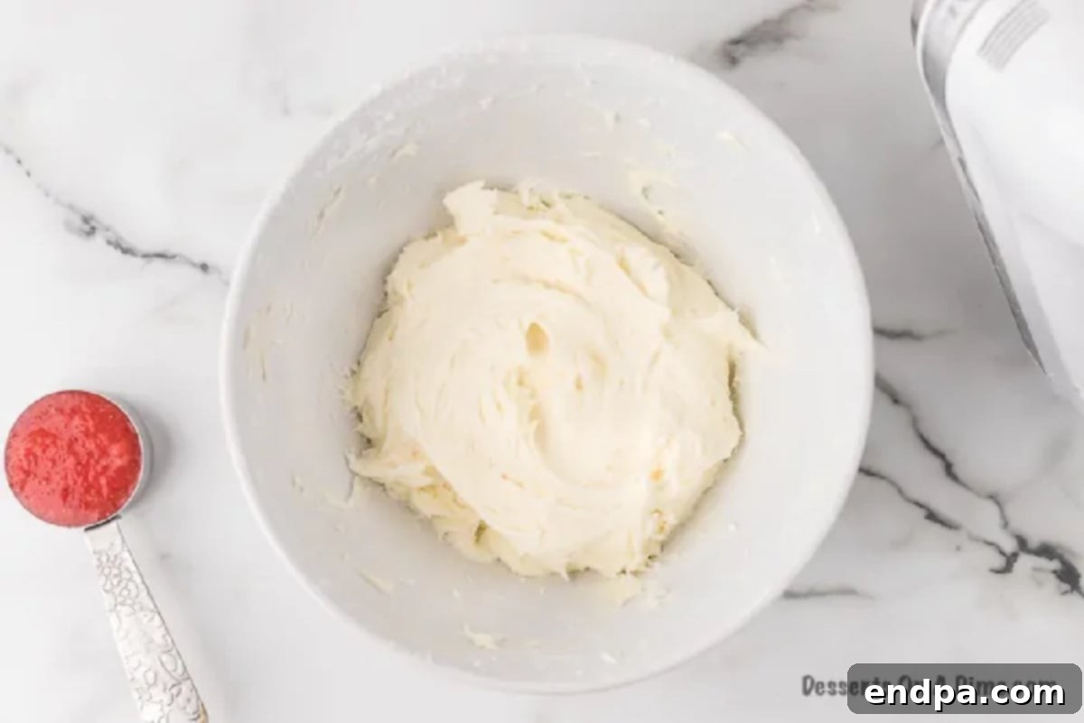 Effortless Strawberry Sheet Cake 5 A bowl containing softened butter, cream cheese, and vanilla extract, ready to be beaten together for the cream cheese frosting.