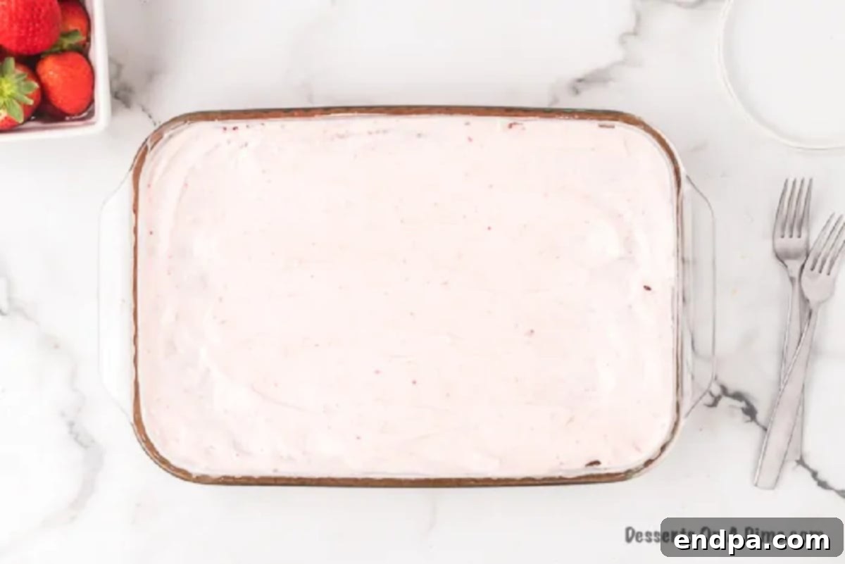 Effortless Strawberry Sheet Cake 7 The finished strawberry cream cheese frosting beautifully spread across the cooled strawberry sheet cake in the baking pan.