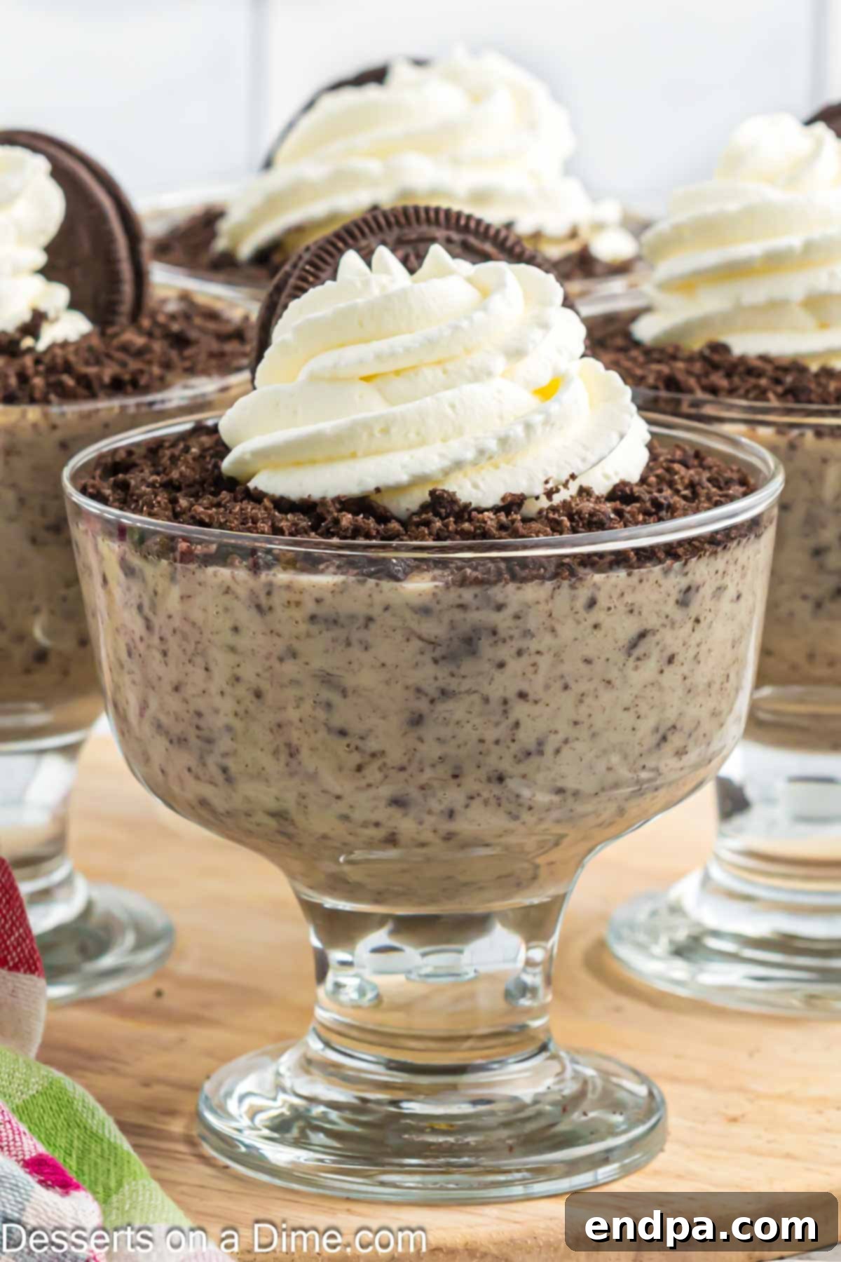 Oreo pudding in a cup, garnished with whipped cream and an Oreo cookie.