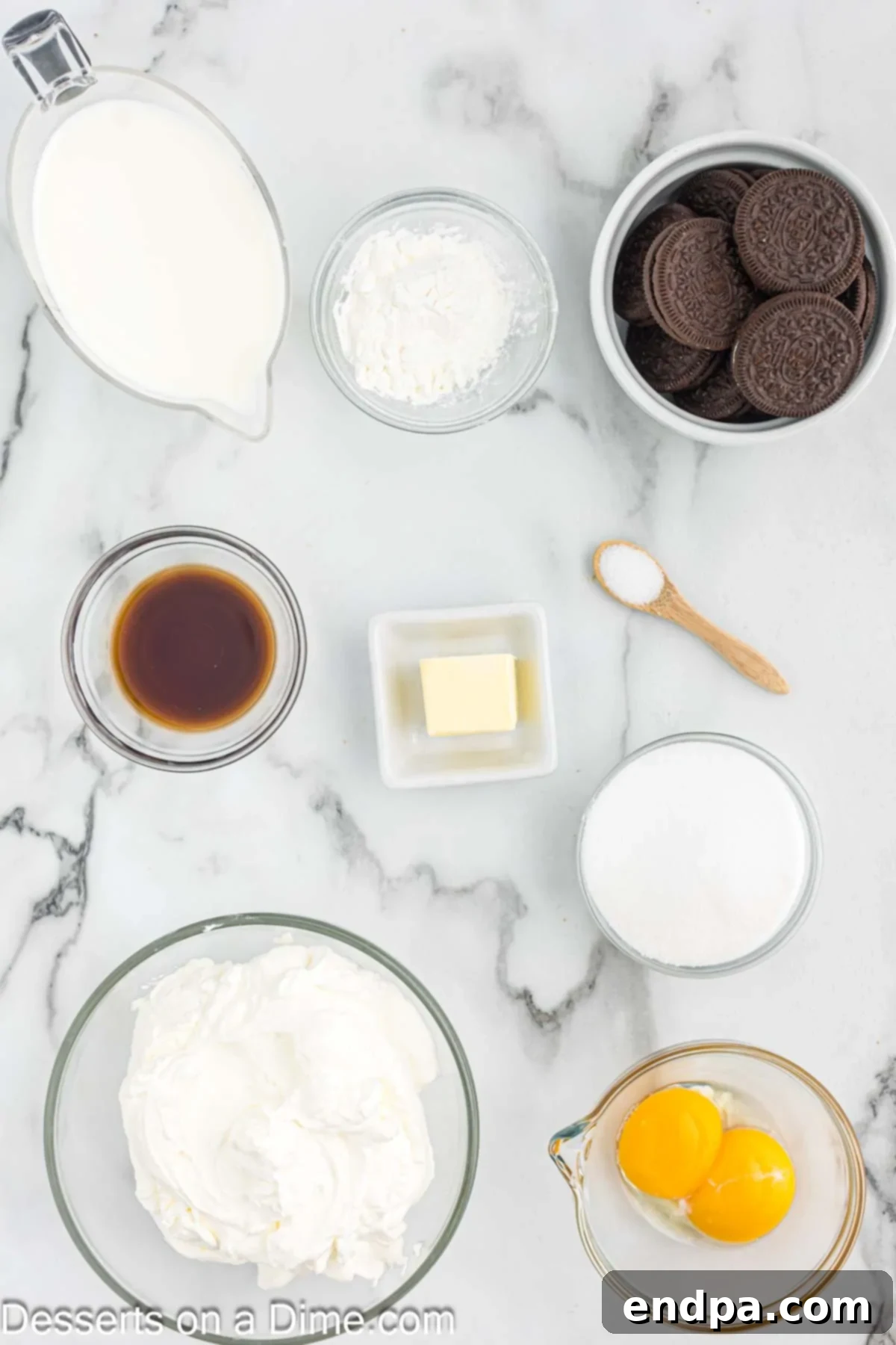 Collection of key ingredients for Oreo pudding: sugar, cornstarch, milk, butter, egg yolks, vanilla, crushed Oreo cookies, whipped cream, and whole Oreos.