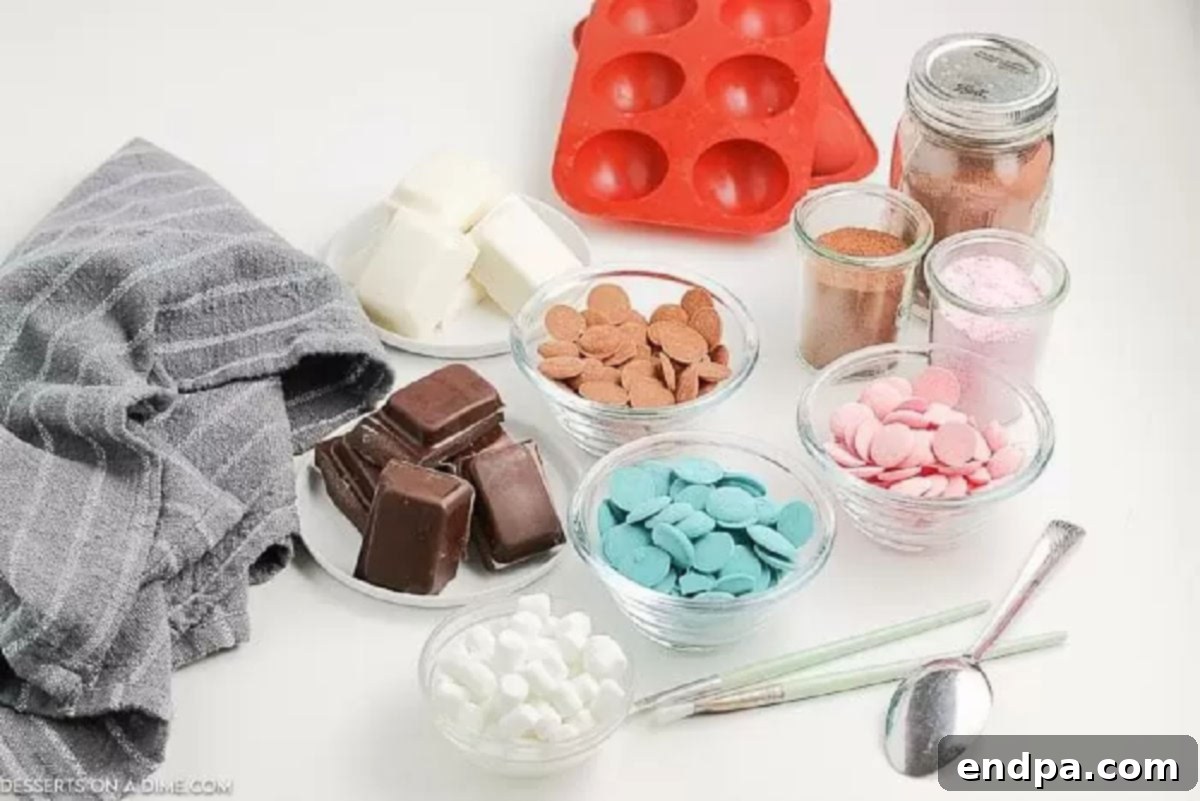 Chocolate, mini marshmallows, hot cocoa mix, silicone dome molds, and a paintbrush laid out for making hot chocolate bombs.