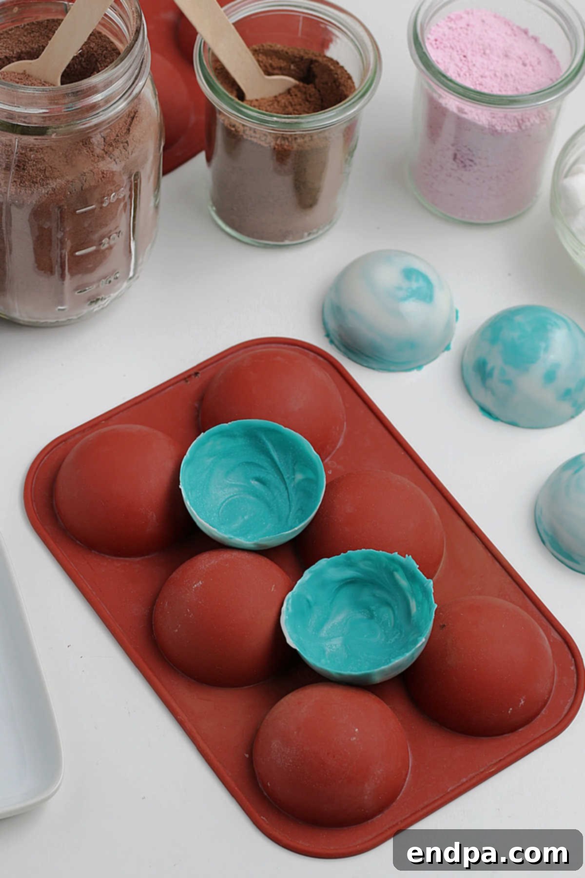 Hardened chocolate half-spheres carefully removed from their silicone molds, ready for filling.