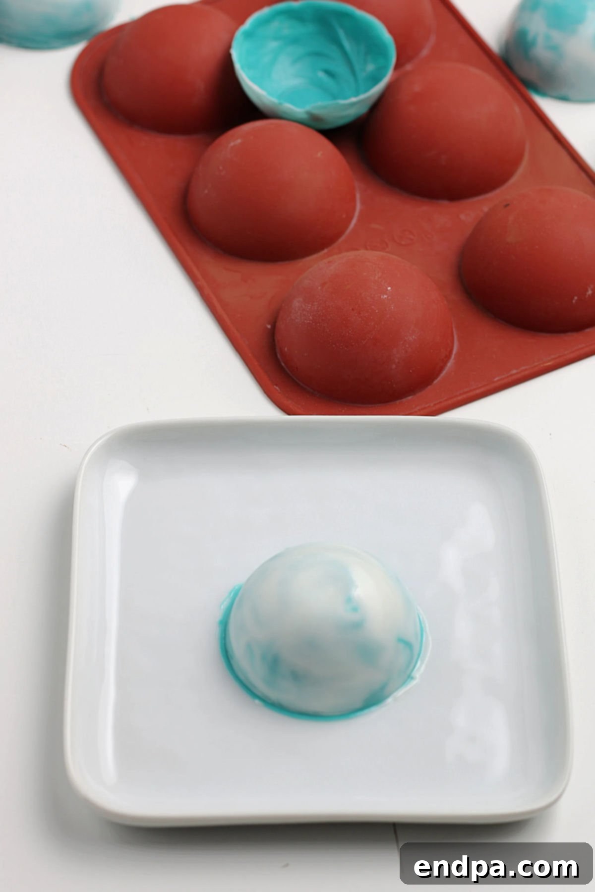 A chocolate half-sphere placed on a warm plate, its edge slightly melting to create a smooth seal.