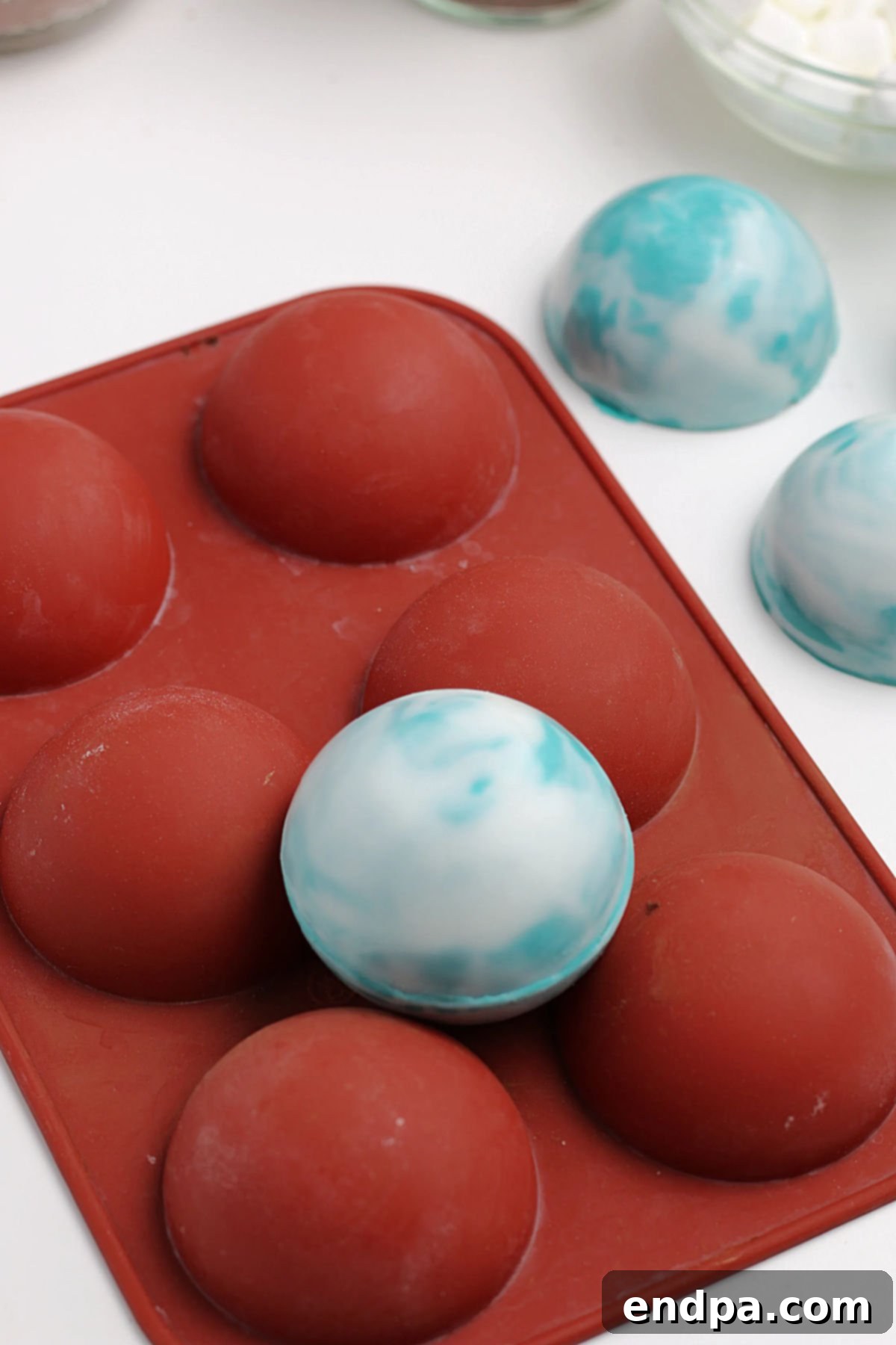 Two chocolate half-spheres sealed together, forming a complete hot chocolate bomb.