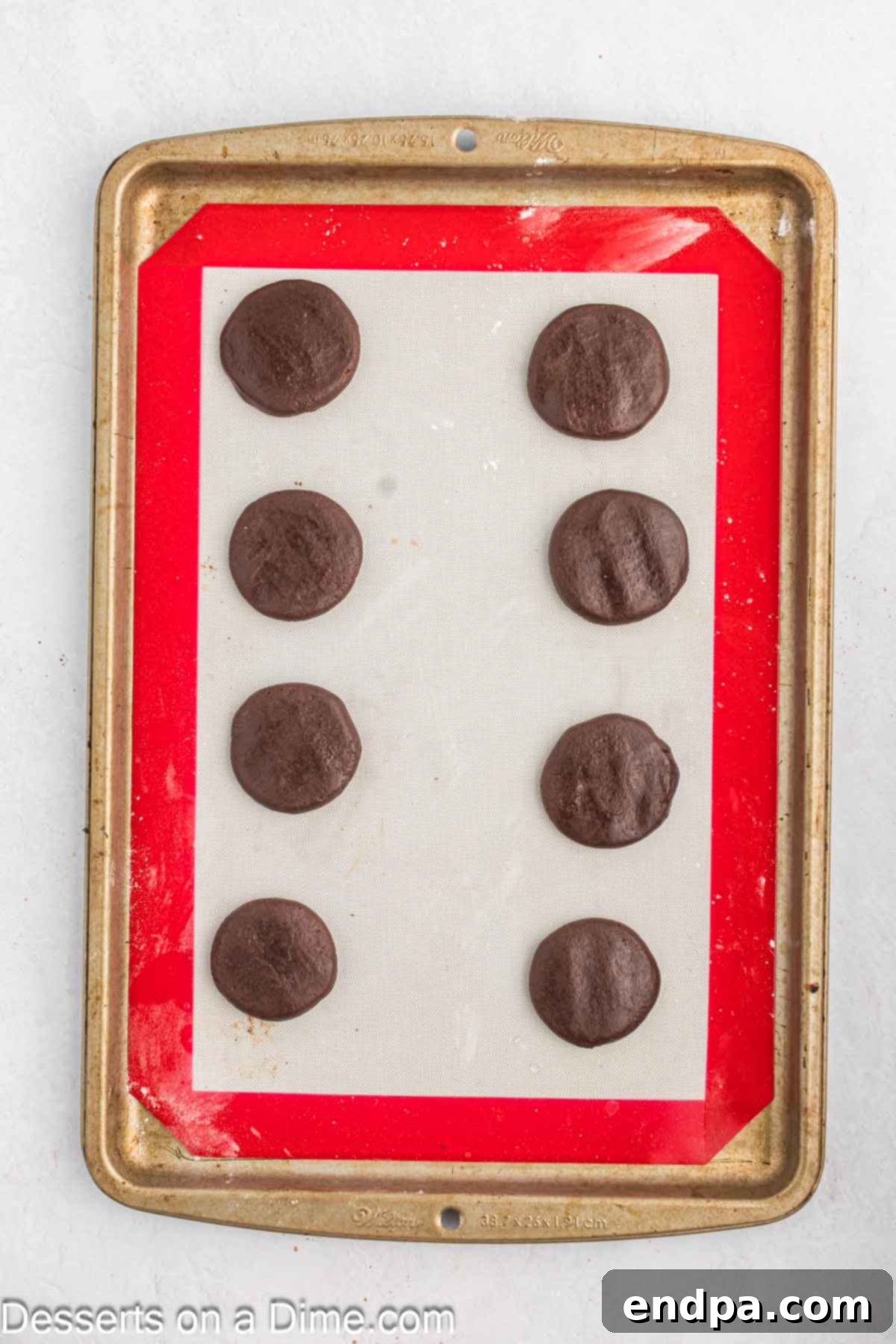 Cookies on mat flattened before baking.
