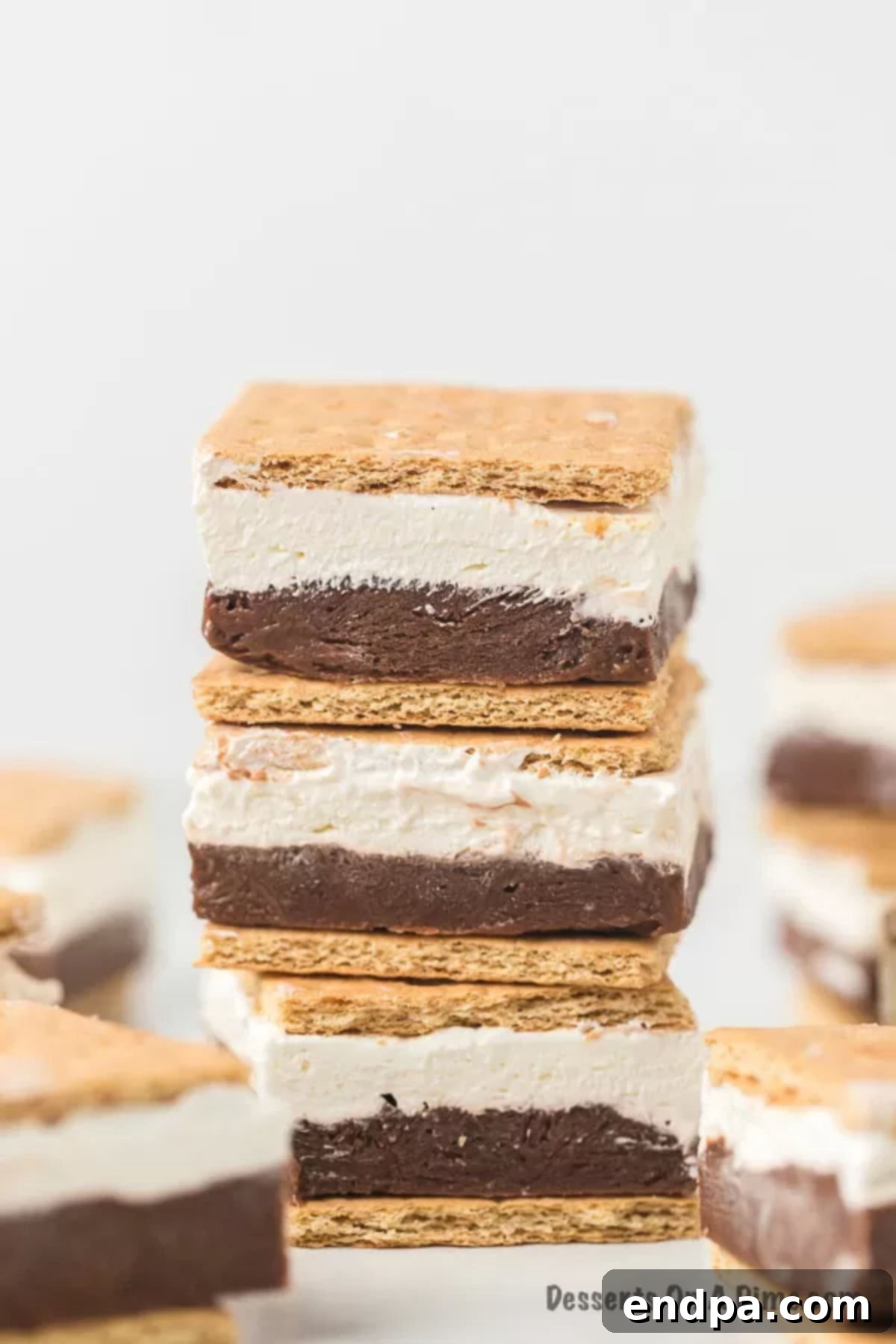 Smores Freeze 2 Frozen S'mores stacked on a plate, showcasing rich layers of chocolate, marshmallow, and graham crackers.