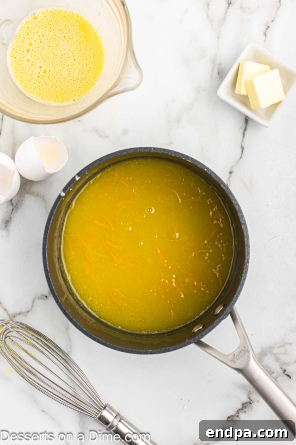 Saucepan with orange juice added to mixture.