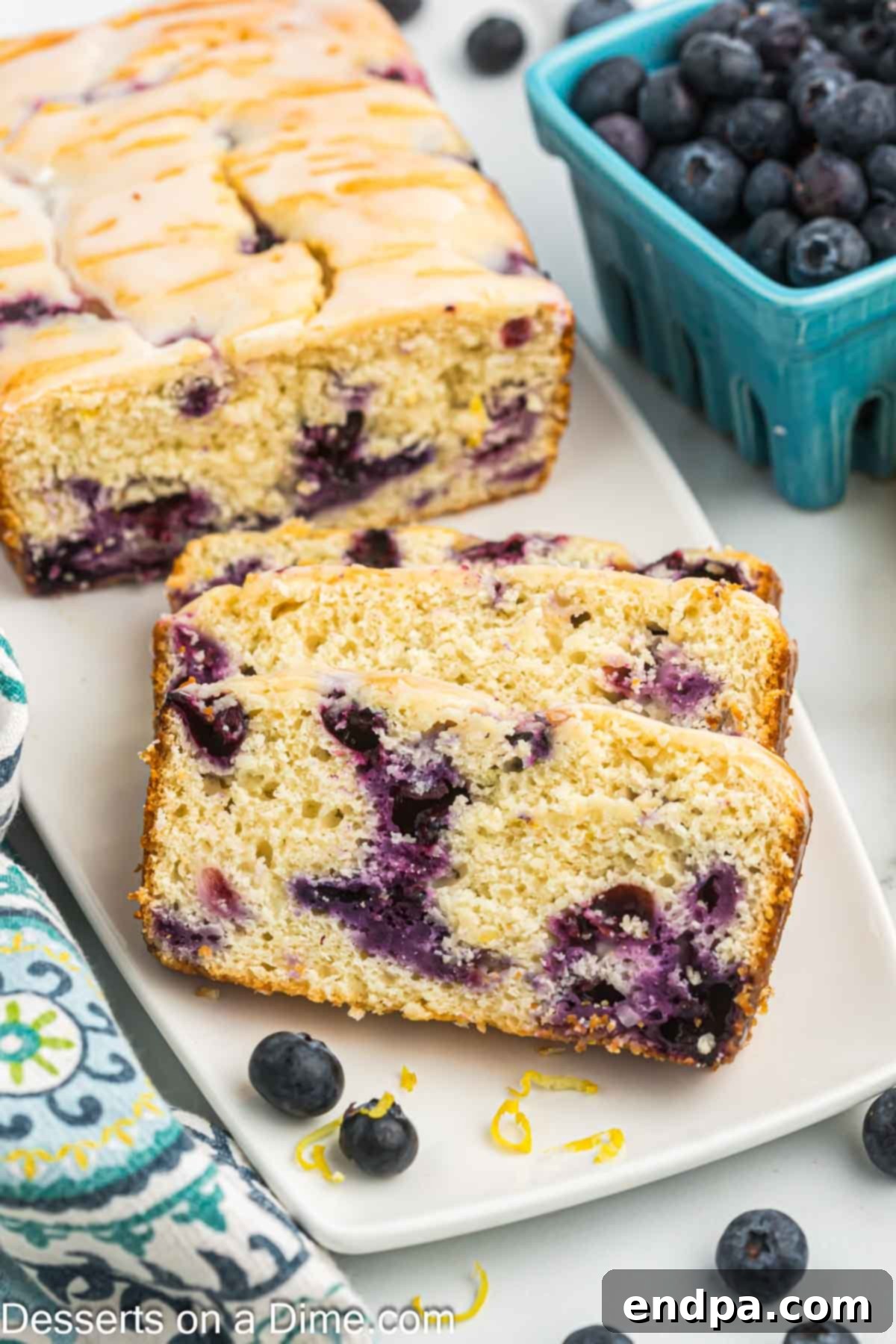 Slices of Lemon Blueberry Bread on a plate, showcasing its moist texture and blueberry specks.