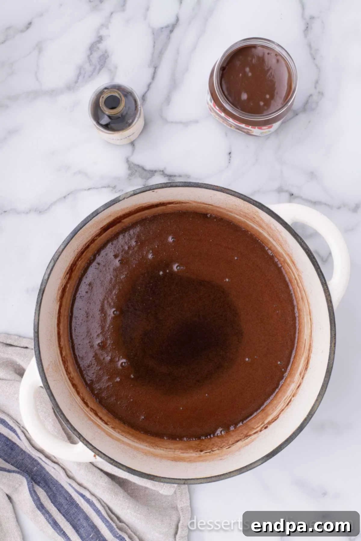 Saucepan with butter, sugar, cocoa and milk combined, beginning to heat on the stovetop.
