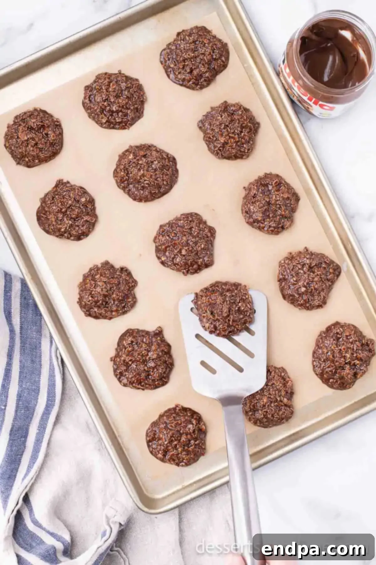 Set Nutella No Bake Cookies being carefully removed from the baking sheet with a spatula.