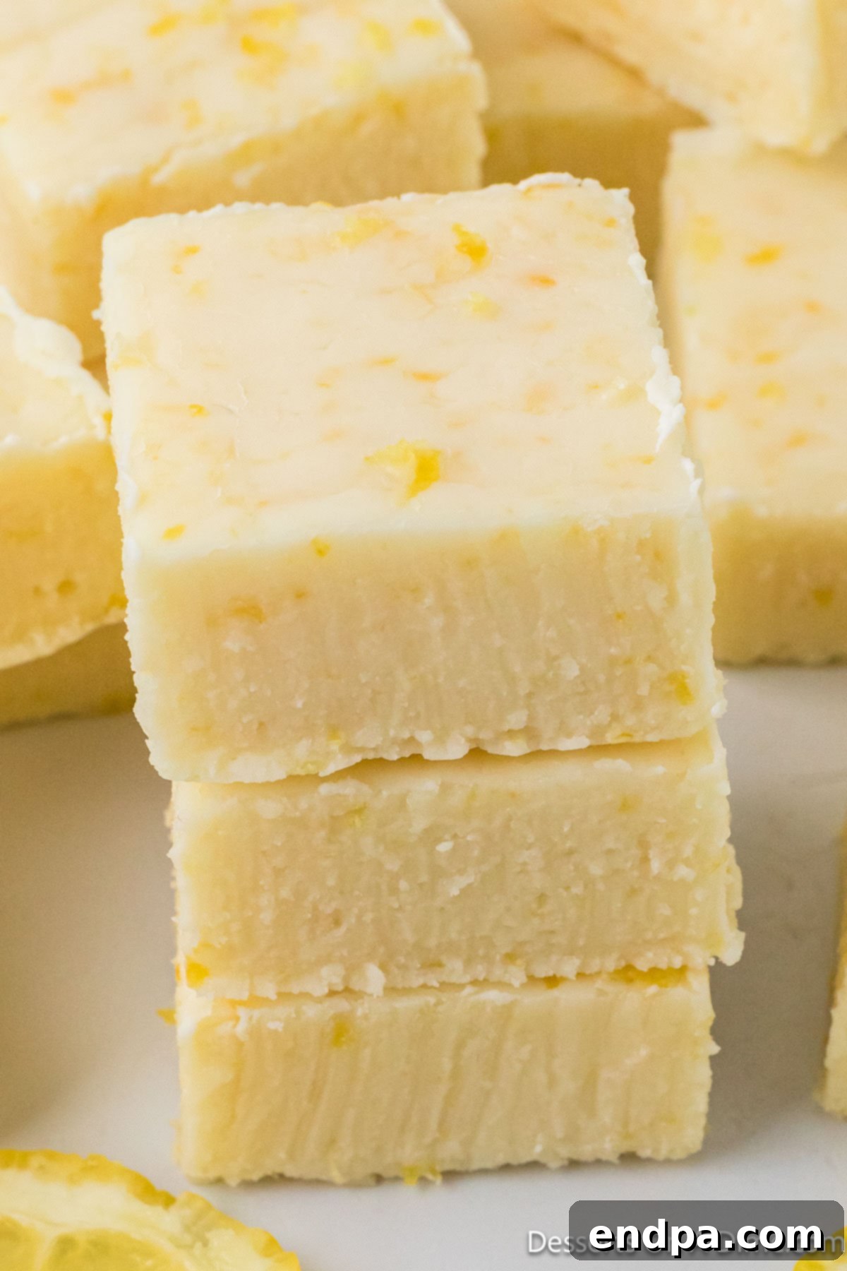 Lemon fudge stacked together, showing its creamy texture and vibrant color.