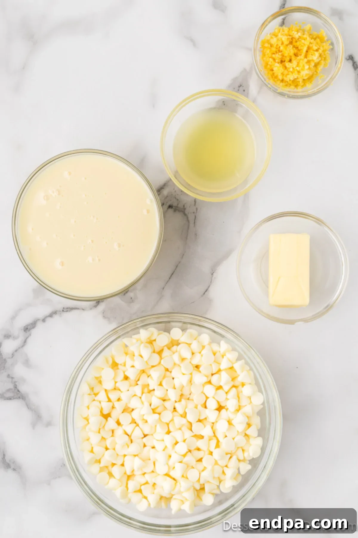 Ingredients for Lemon Fudge laid out: White chocolate chips, sweetened condensed milk, unsalted butter, fresh lemon juice, and lemon zest.