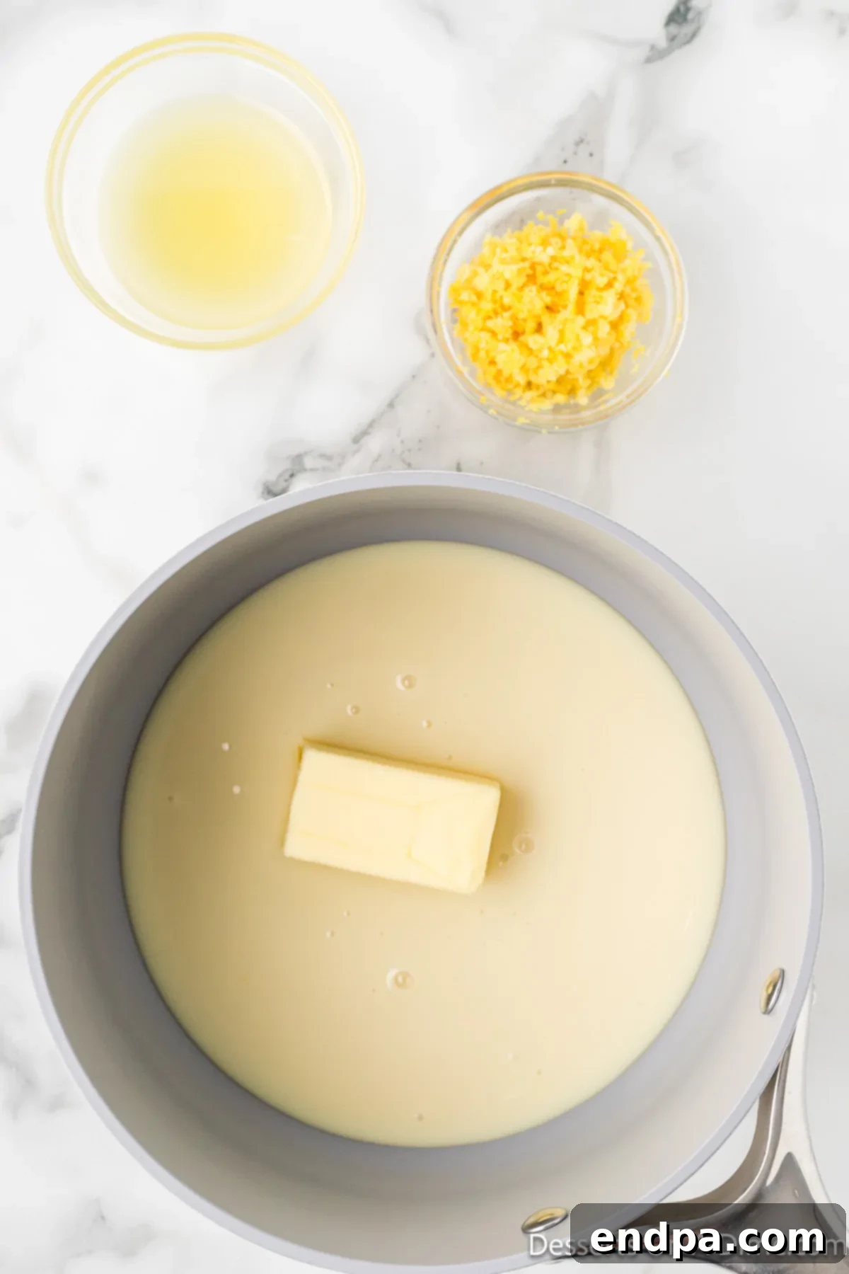 Saucepan with sweetened condensed milk, butter, lemon juice and lemon zest heating gently.
