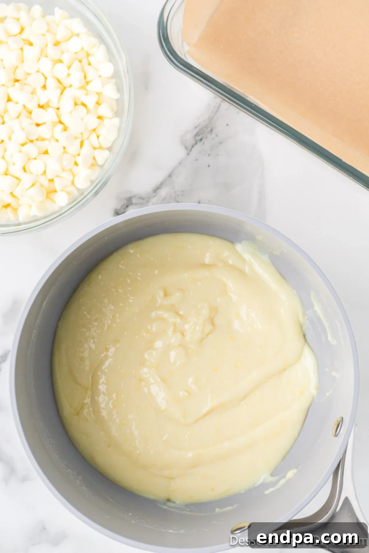 Mixture of sweetened condensed milk, butter, lemon juice, and lemon zest combined and bubbling gently.