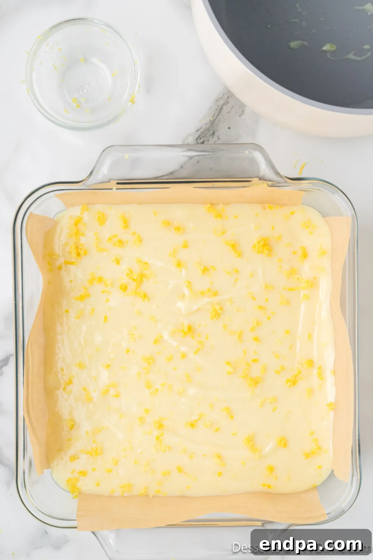Lemon fudge mixture spread evenly into the prepared pan and topped with fresh lemon zest.