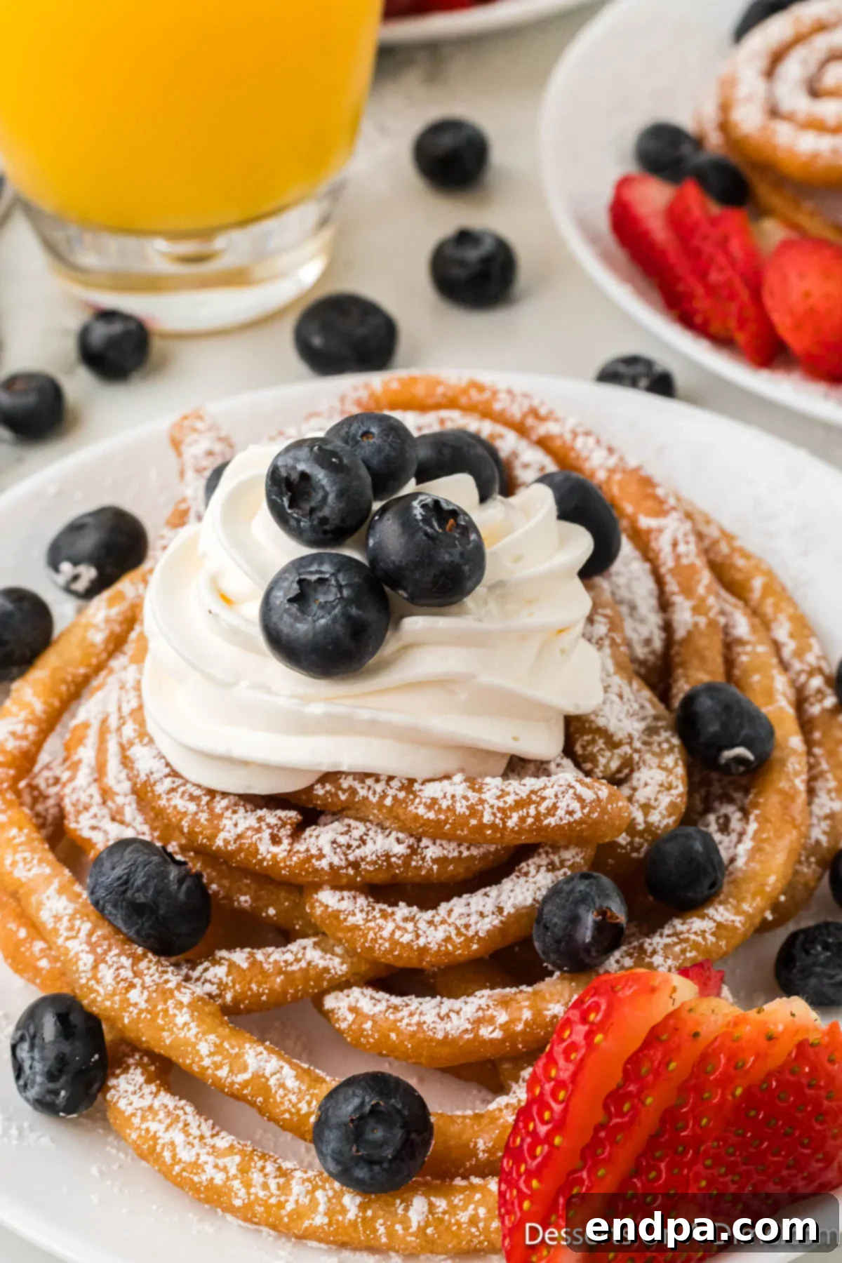 Funnel Cake topped with fruit and whipped cream.
