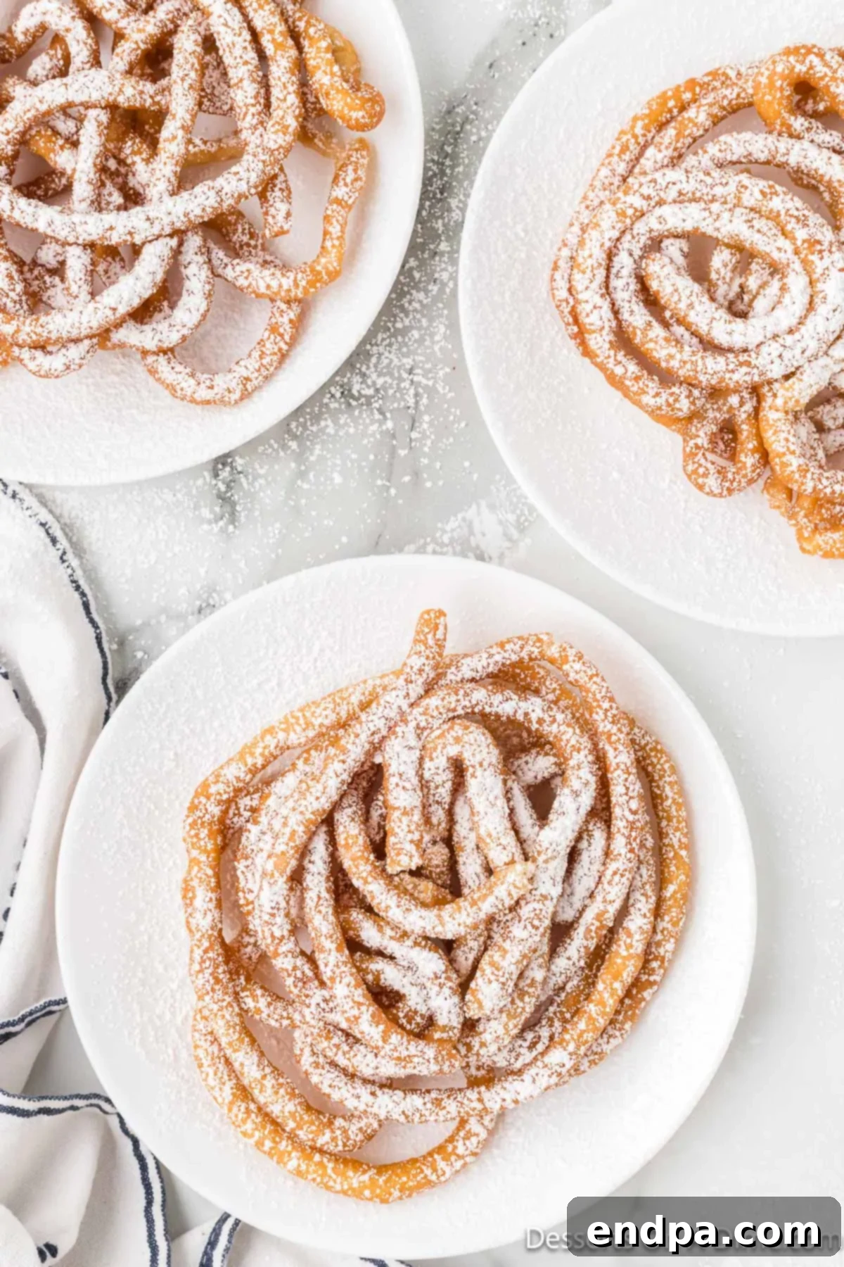 Funnel Cake with cake mix on plates topped with powdered sugar.