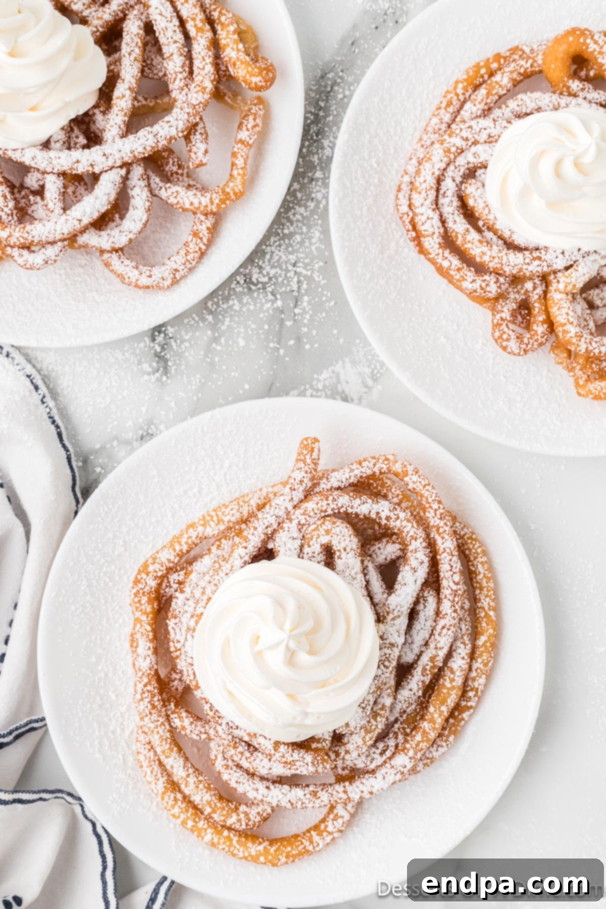 Funnel Cakes with powdered sugar and whipped cream.