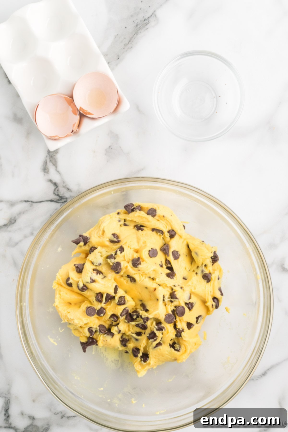 Irresistible Chocolate Chip Cake Mix Cookies 5 Chocolate chips gently folded into the thick cookie dough batter in a mixing bowl.